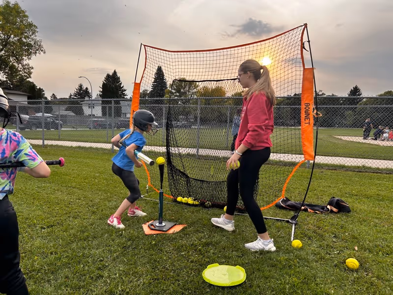 Young player at tee-ball practice at sunset