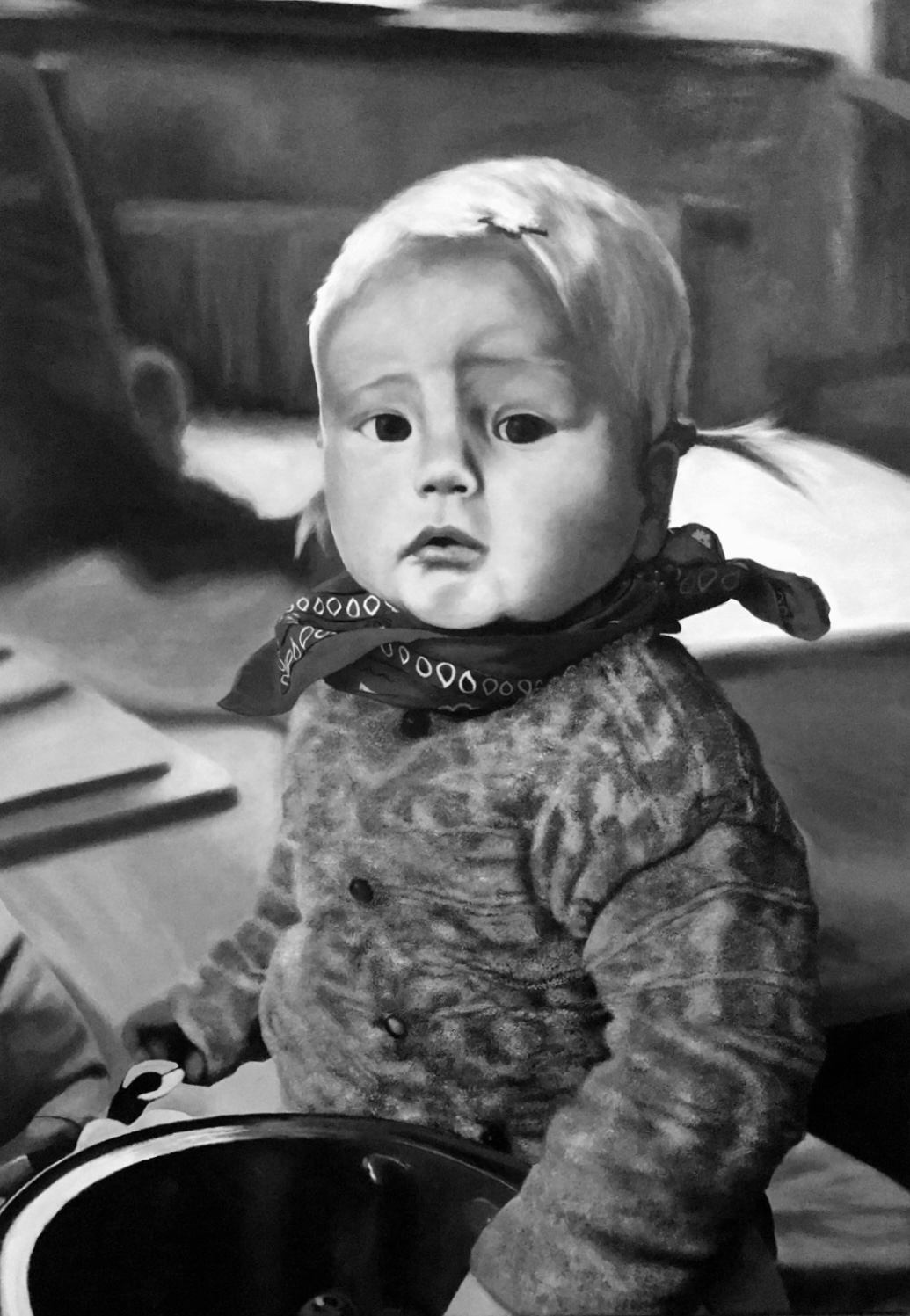 Black and white photo of a toddler with pigtails wearing a patterned sweater and bandana, holding a pot.