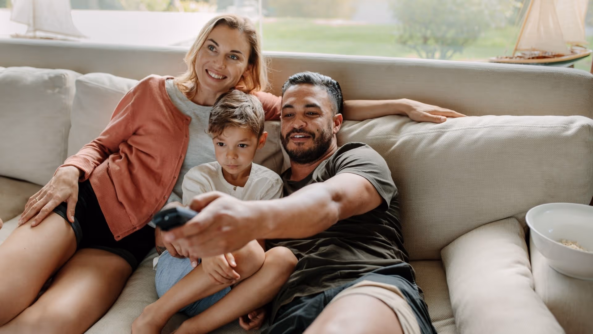 Family on couch featuring man with remote control stock image