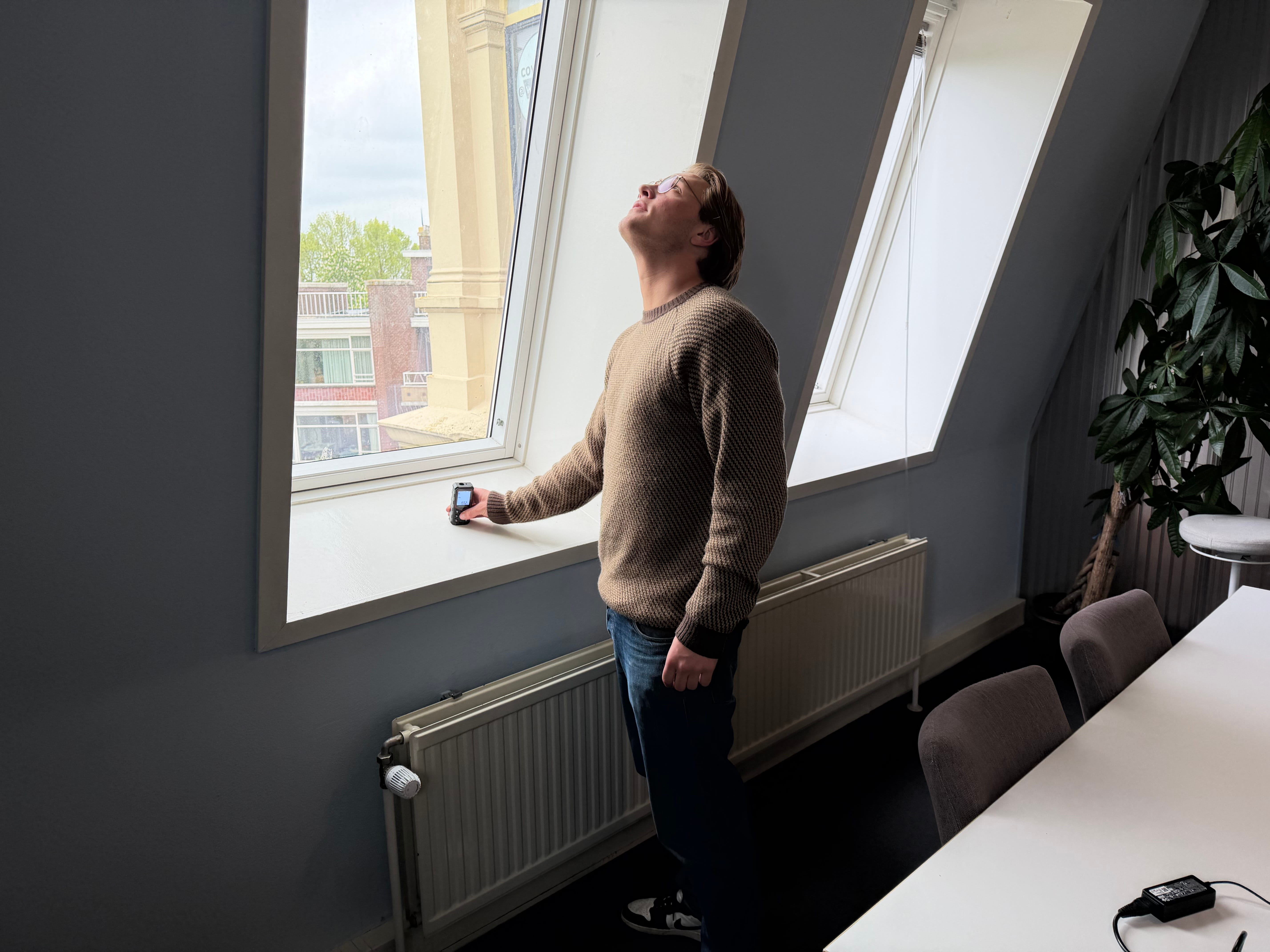 Energieadviseur meet een raam op met een lasermeter tijdens een woningopname