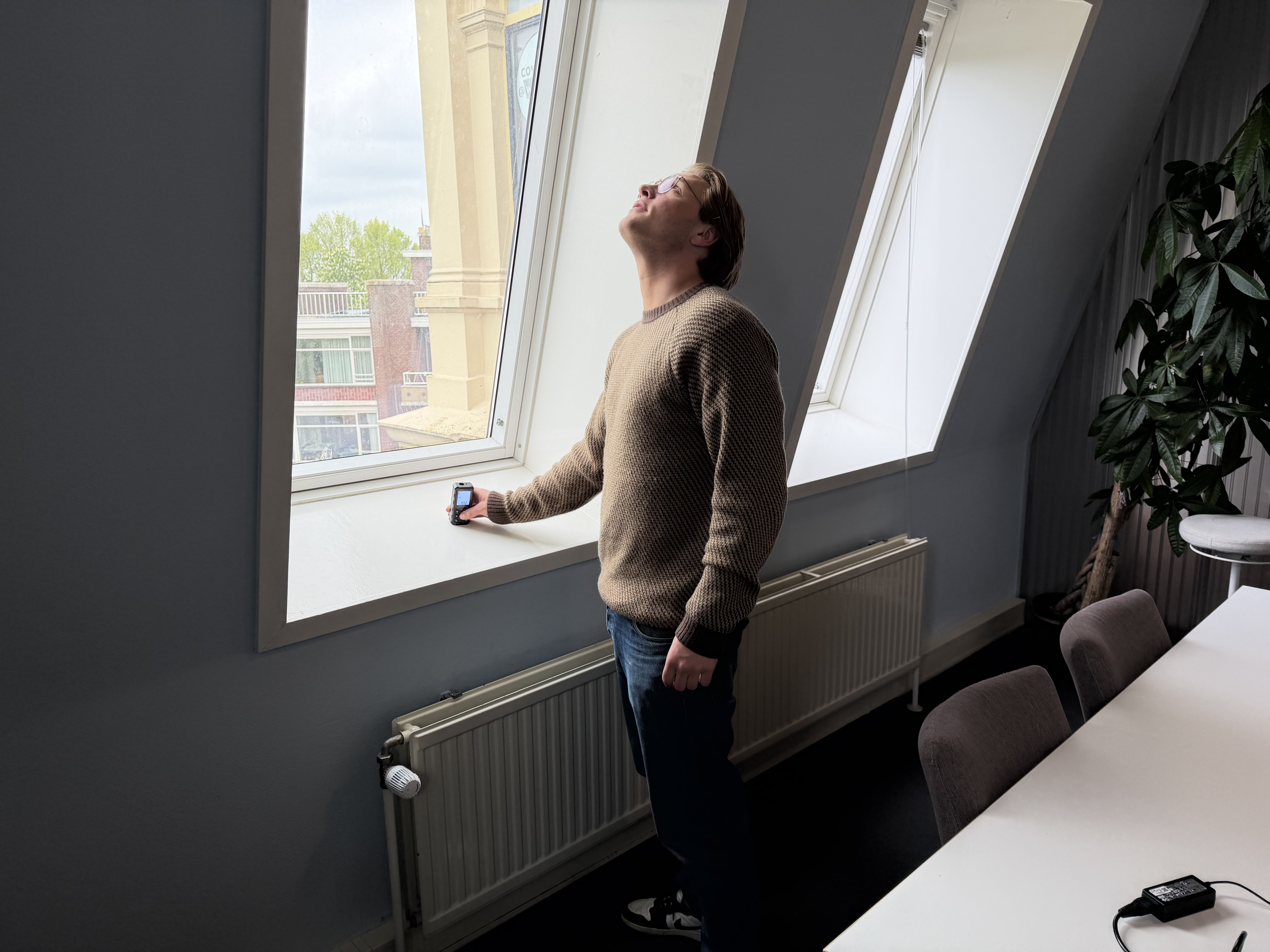 Energieadviseur meet een raam op met een lasermeter tijdens een woningopname