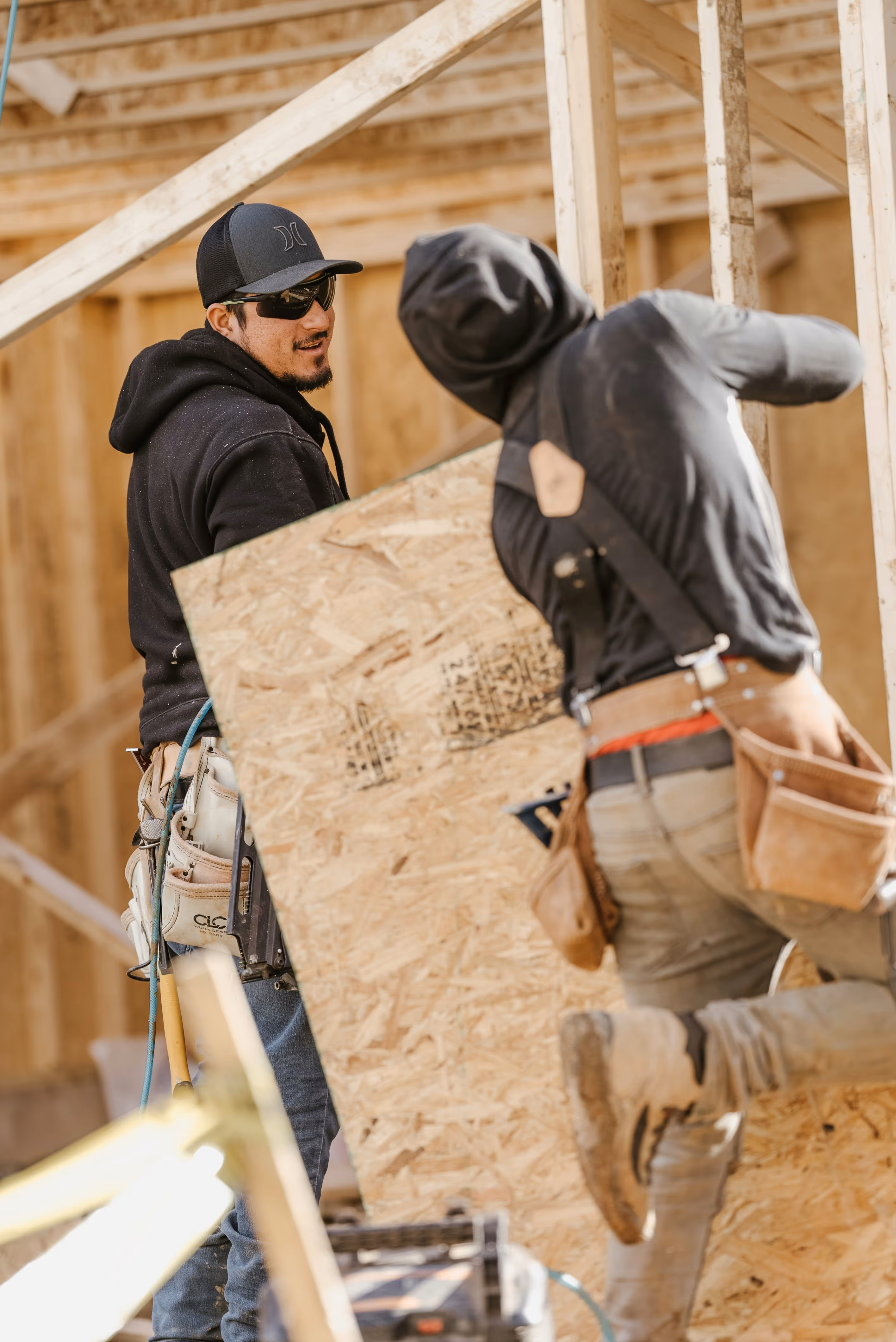 Professional contractor in a hard hat reviewing blueprints on a construction site, illustrating TrueSpan Group’s specialized contractor insurance programs.