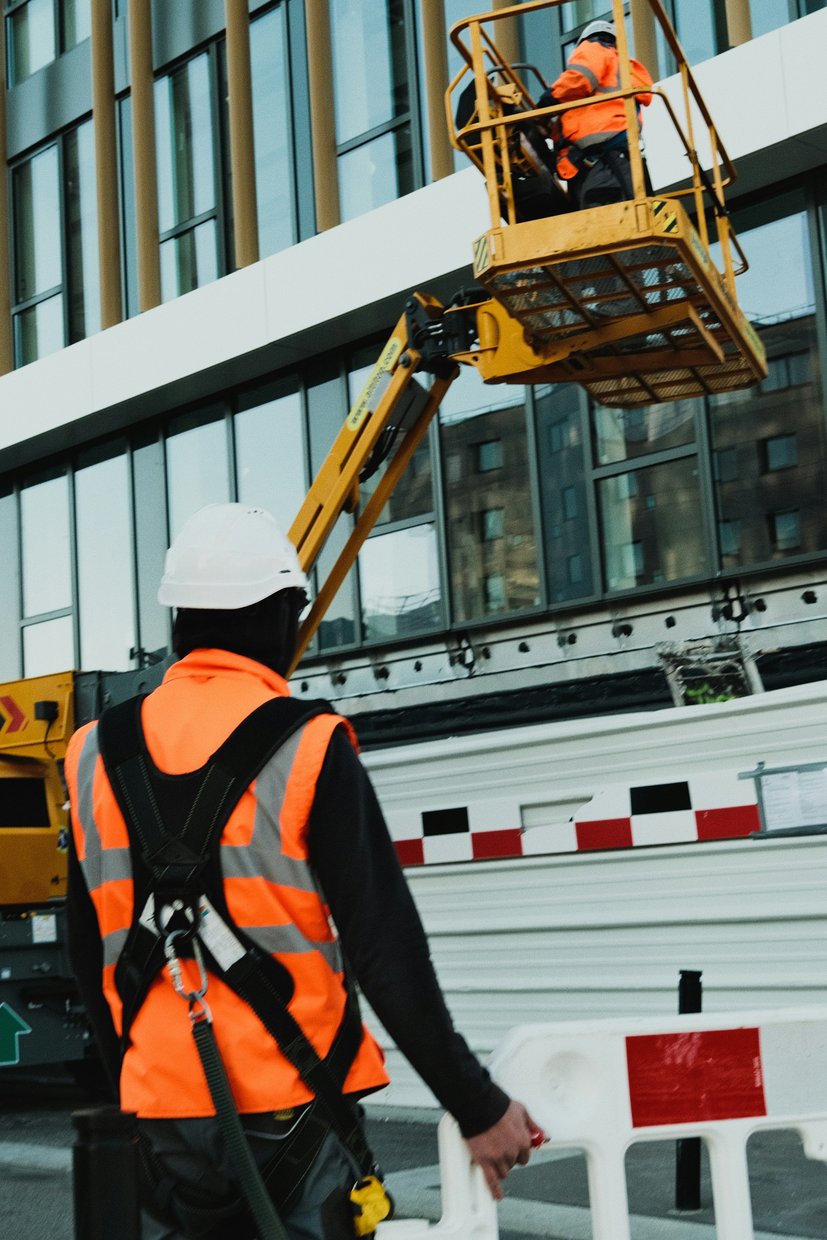 A construction professional wearing a safety harness and hard hat operating an aerial lift, representing TrueSpan Group’s focus on workplace safety and Workers’ Comp advocacy.