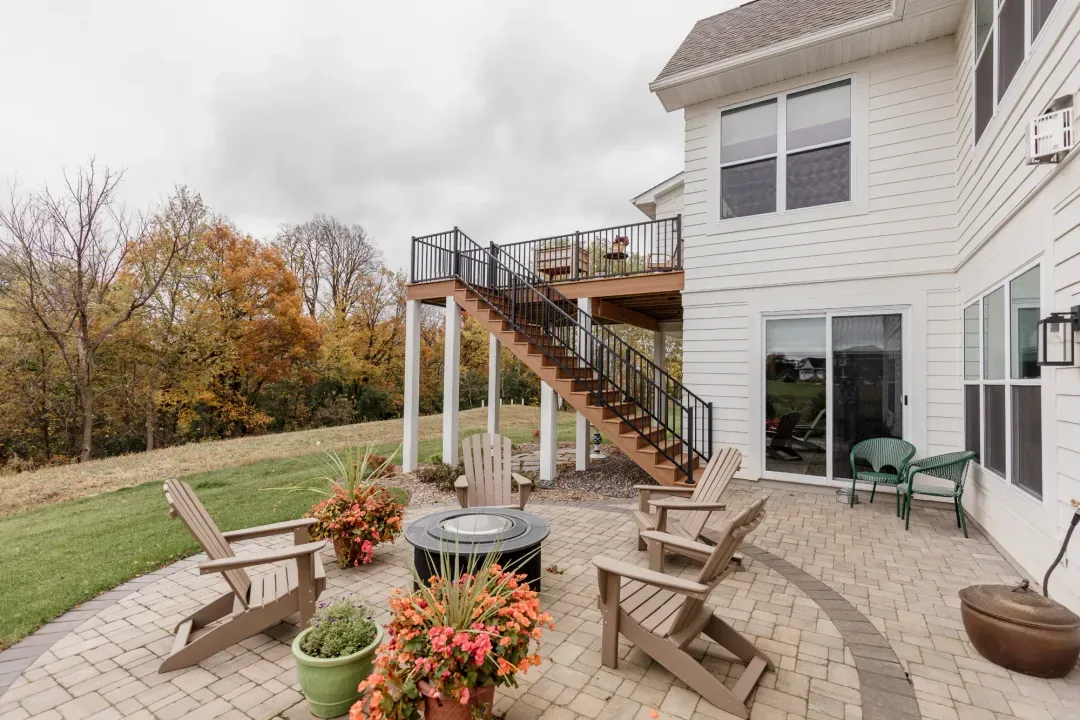Backyard patio with seating beside the house