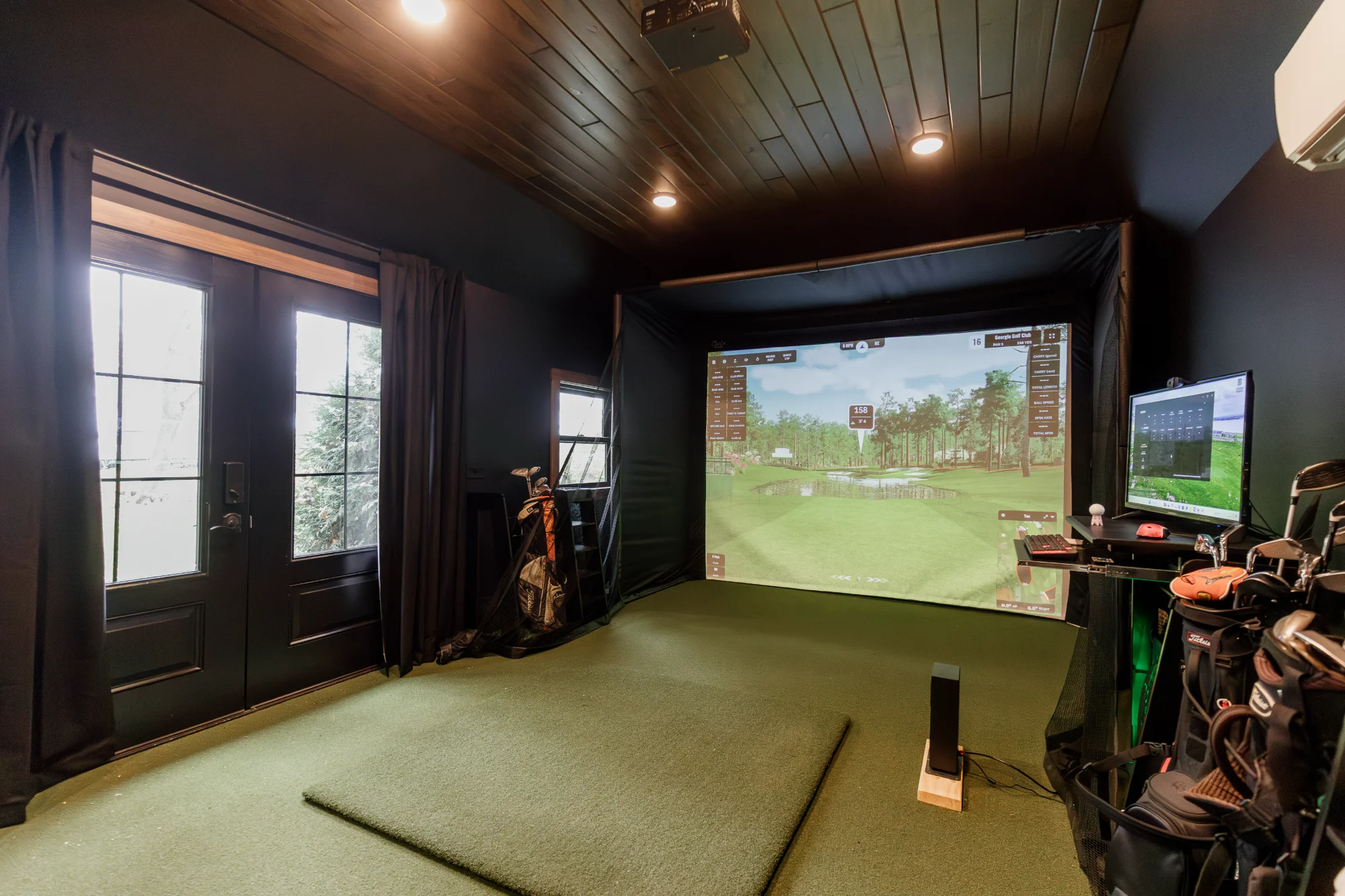 Golf simulator room with window and projector screen