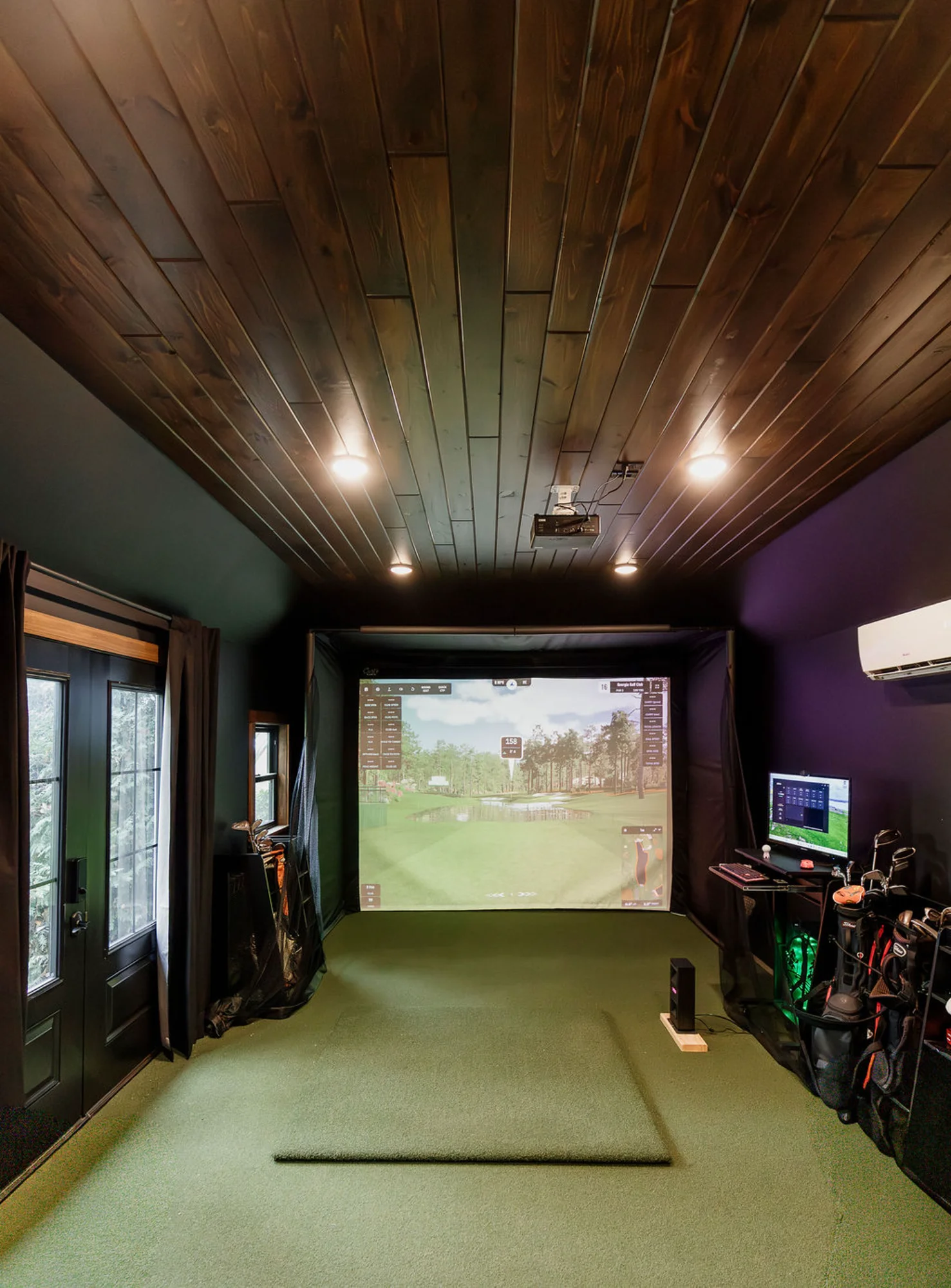 Indoor golf simulator room with projection screen