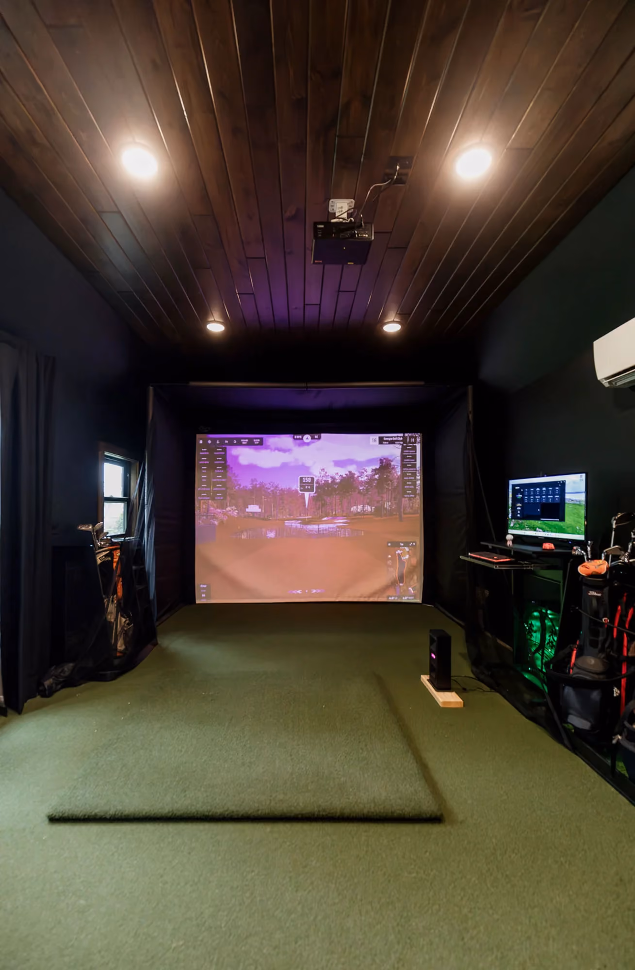Indoor golf simulator room with purple lighting