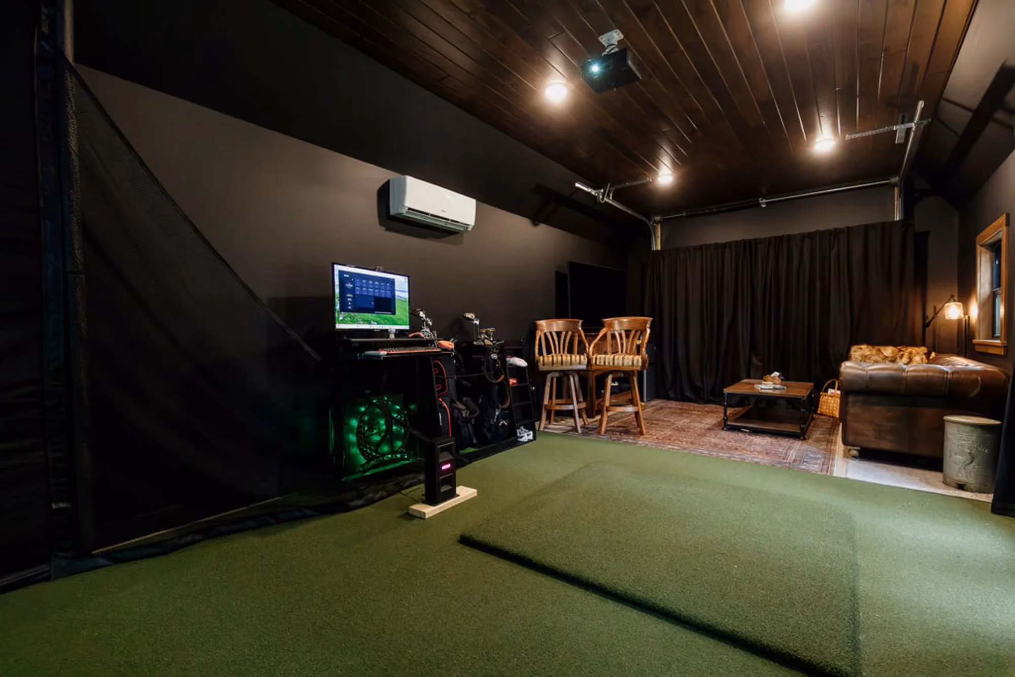Golf simulator room with seating and equipment