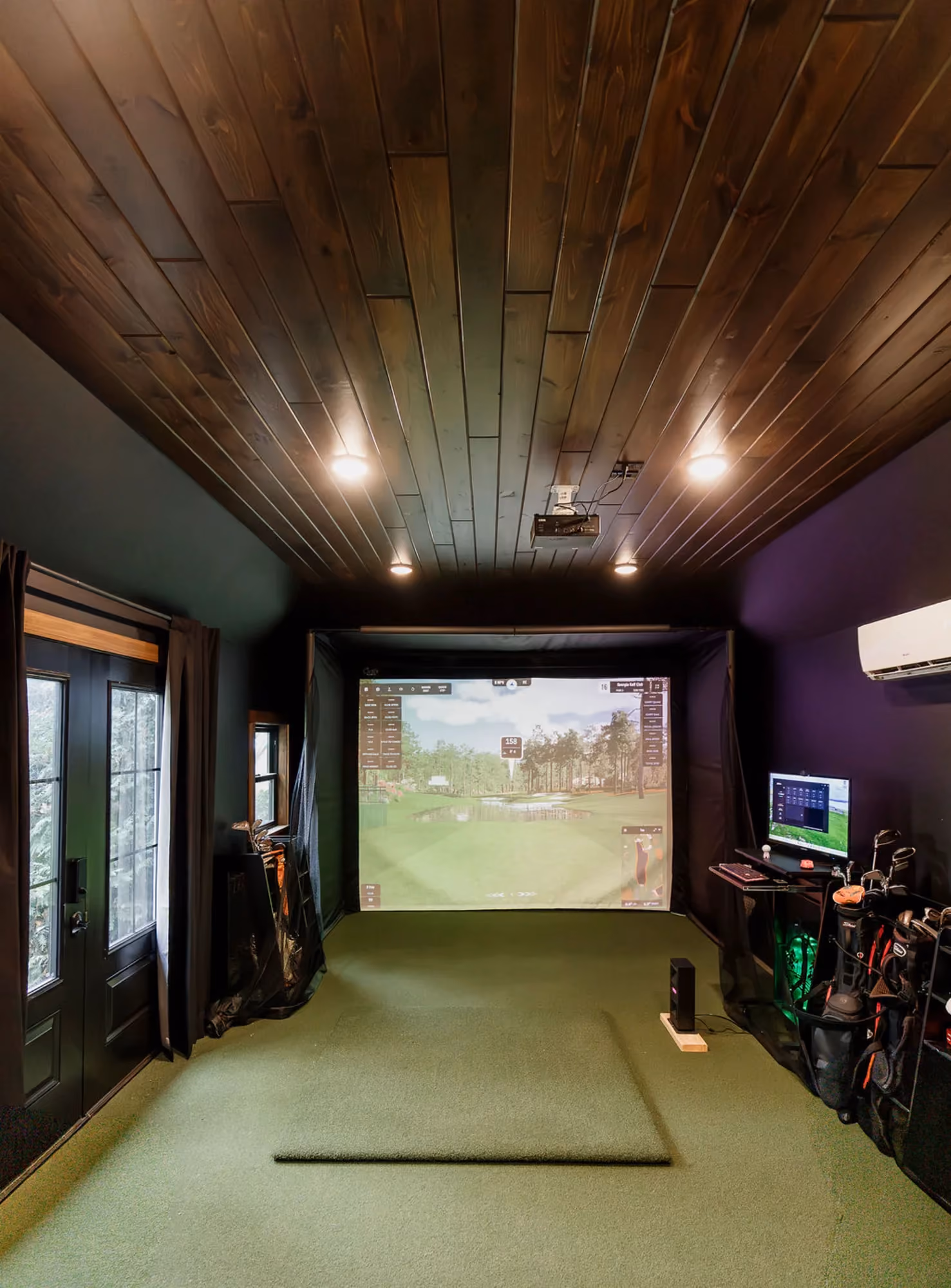 Indoor golf simulator room with projection screen