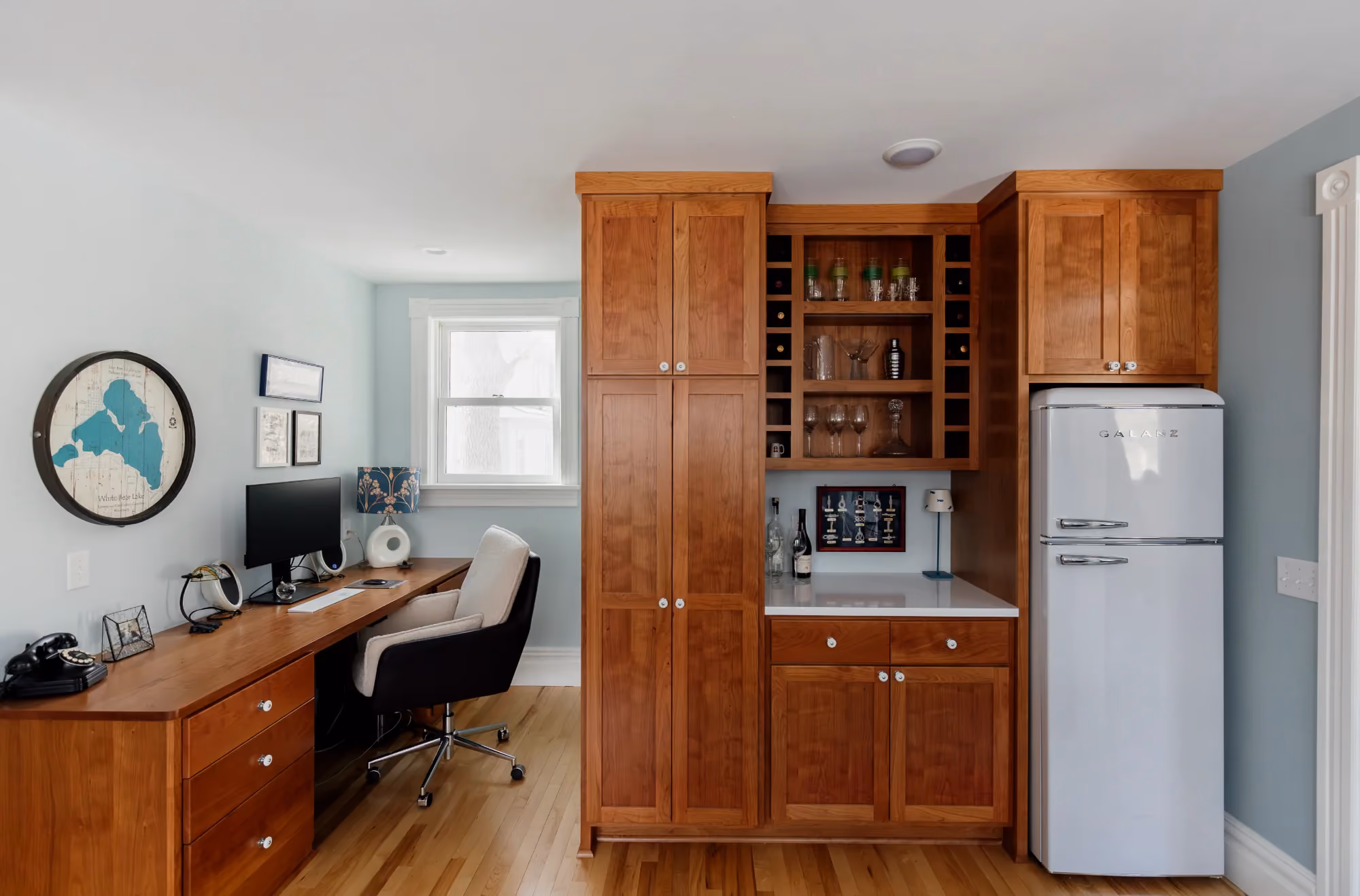 Kitchen area with wooden cabinets, desk nook, and refrigerator