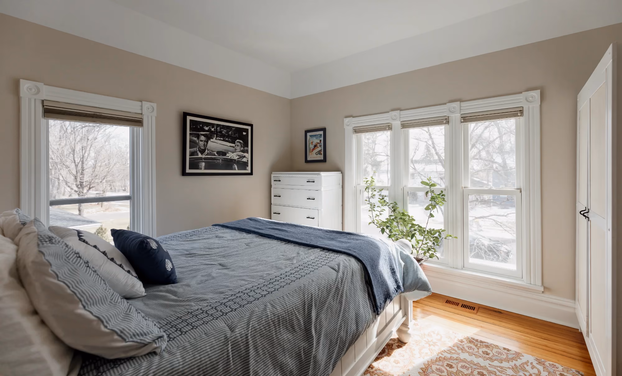 Bedroom with gray bedding and bay windows