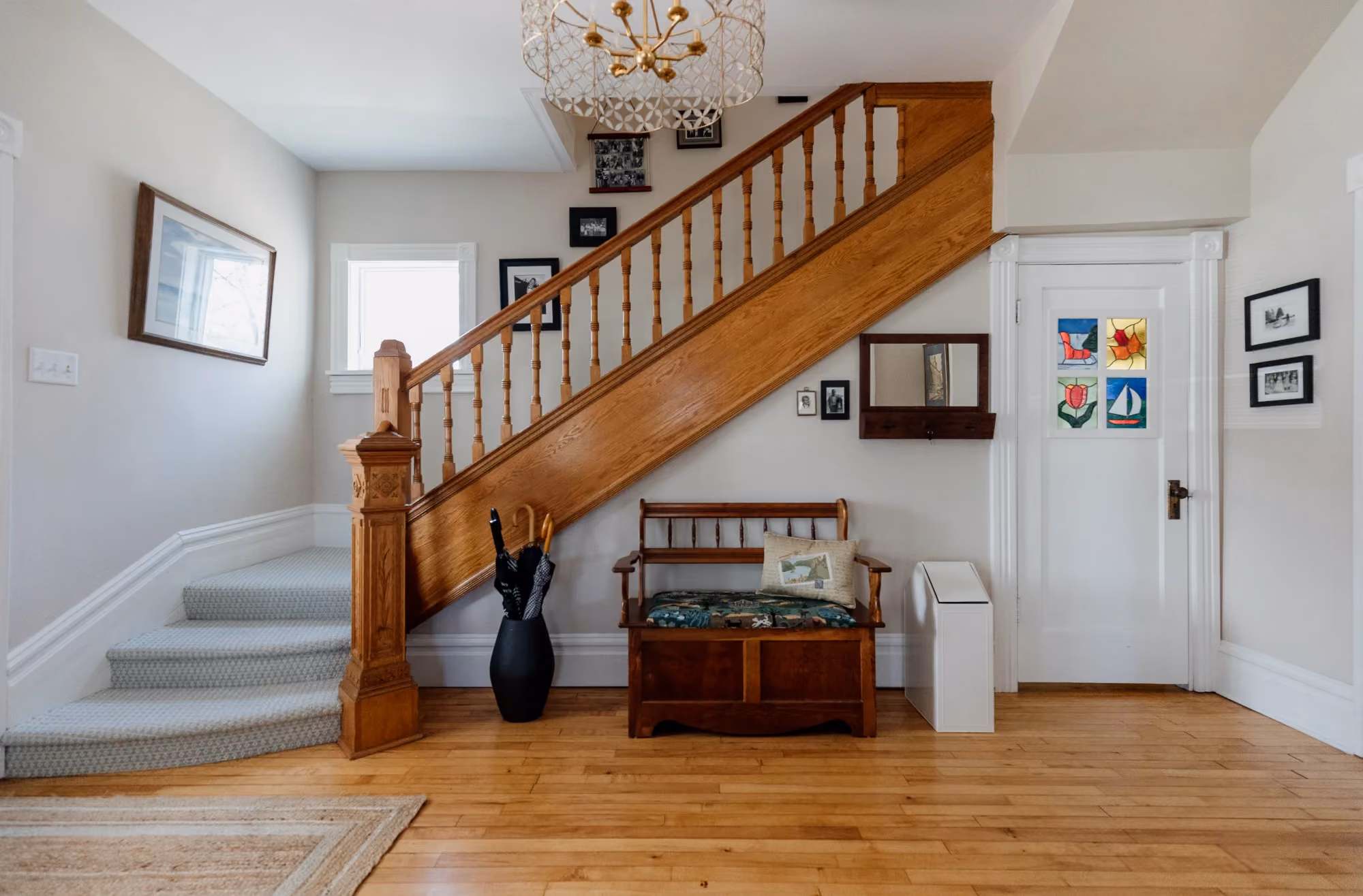 Staircase with wooden banister and entry bench