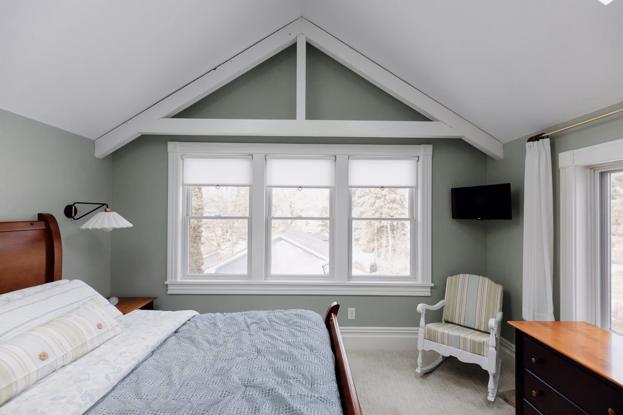 Bedroom with vaulted ceiling and large windows