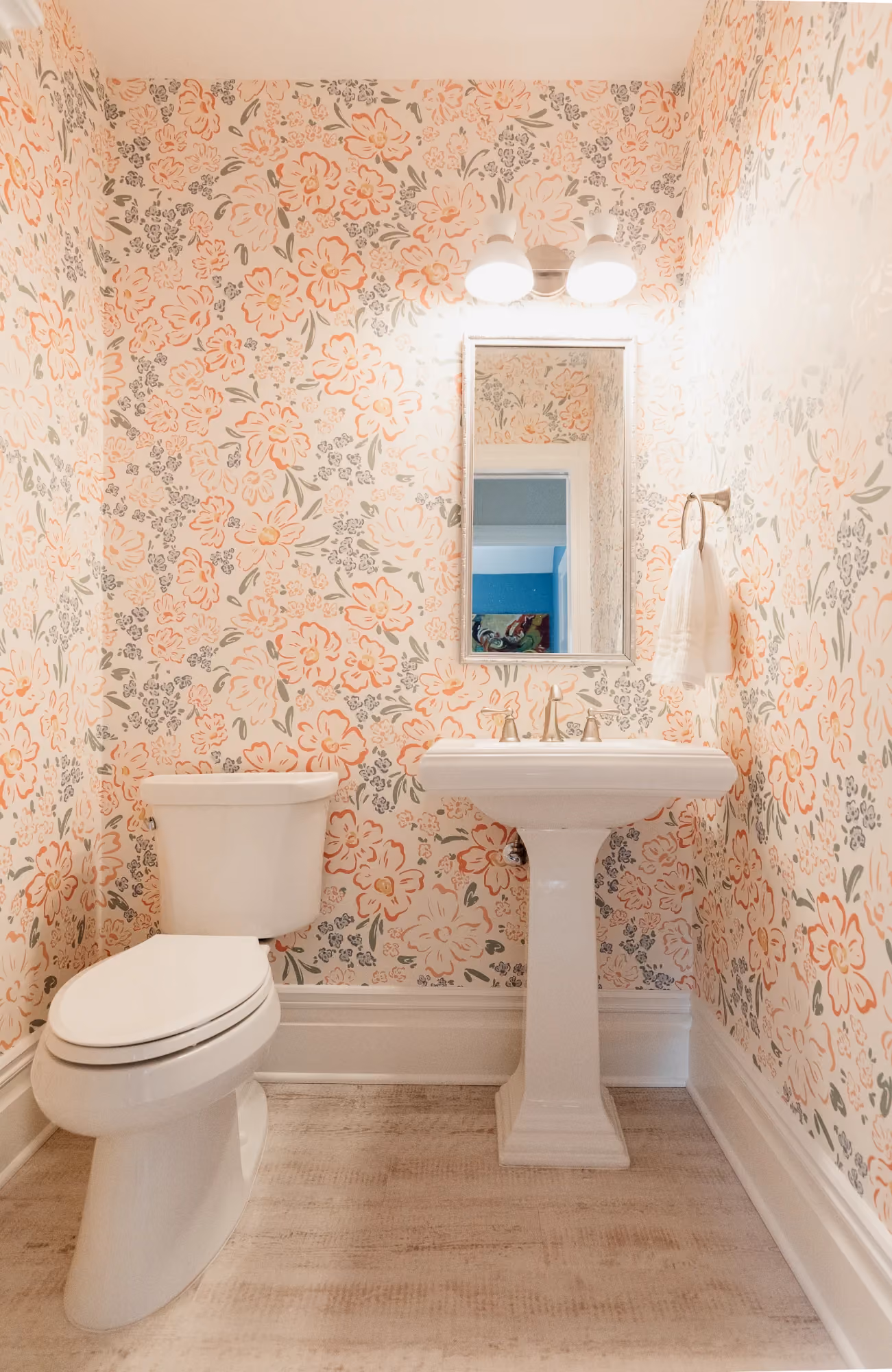 Bathroom with toilet, pedestal sink, and floral wallpaper