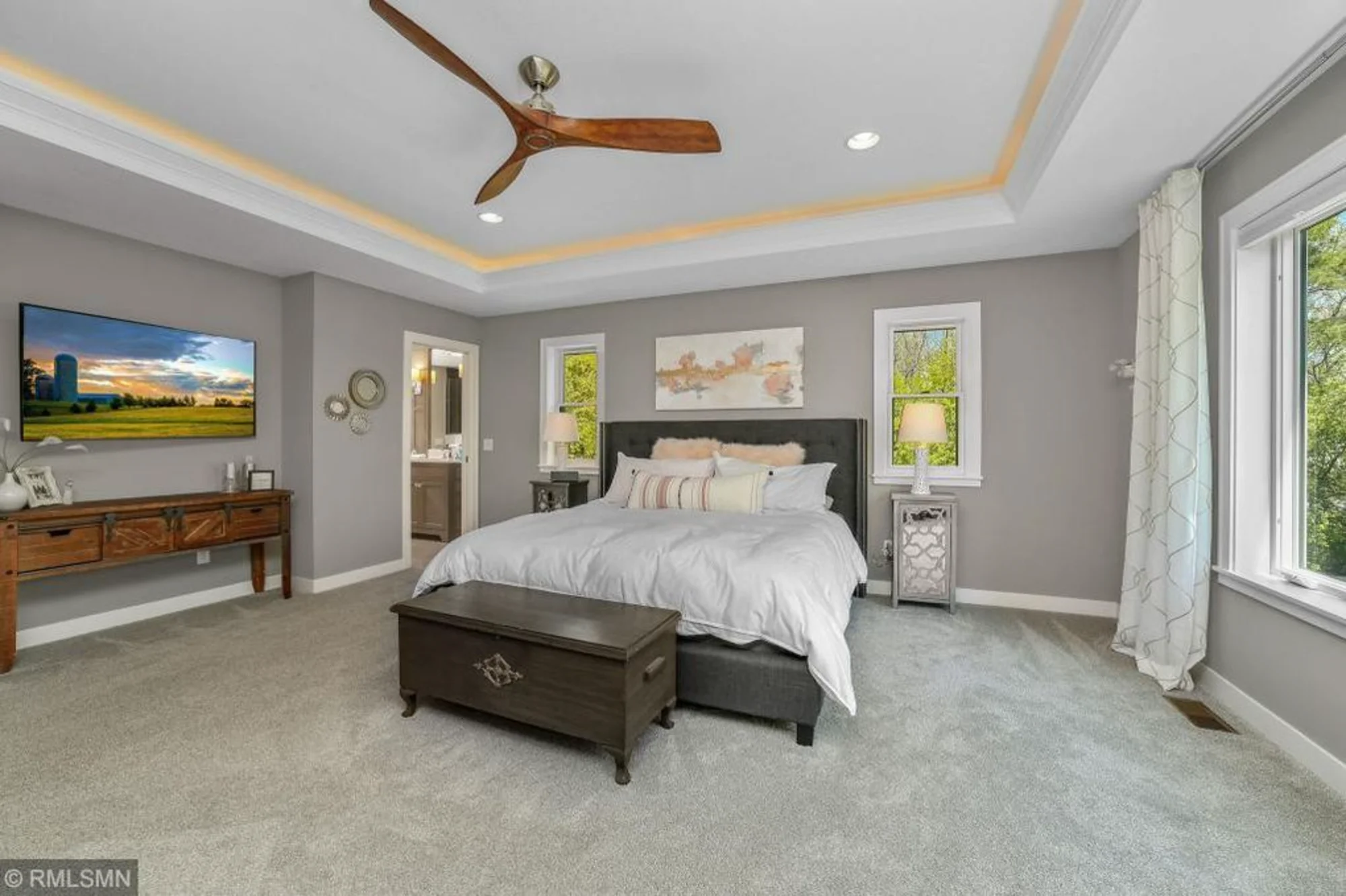Spacious bedroom with tray ceiling and ceiling fan