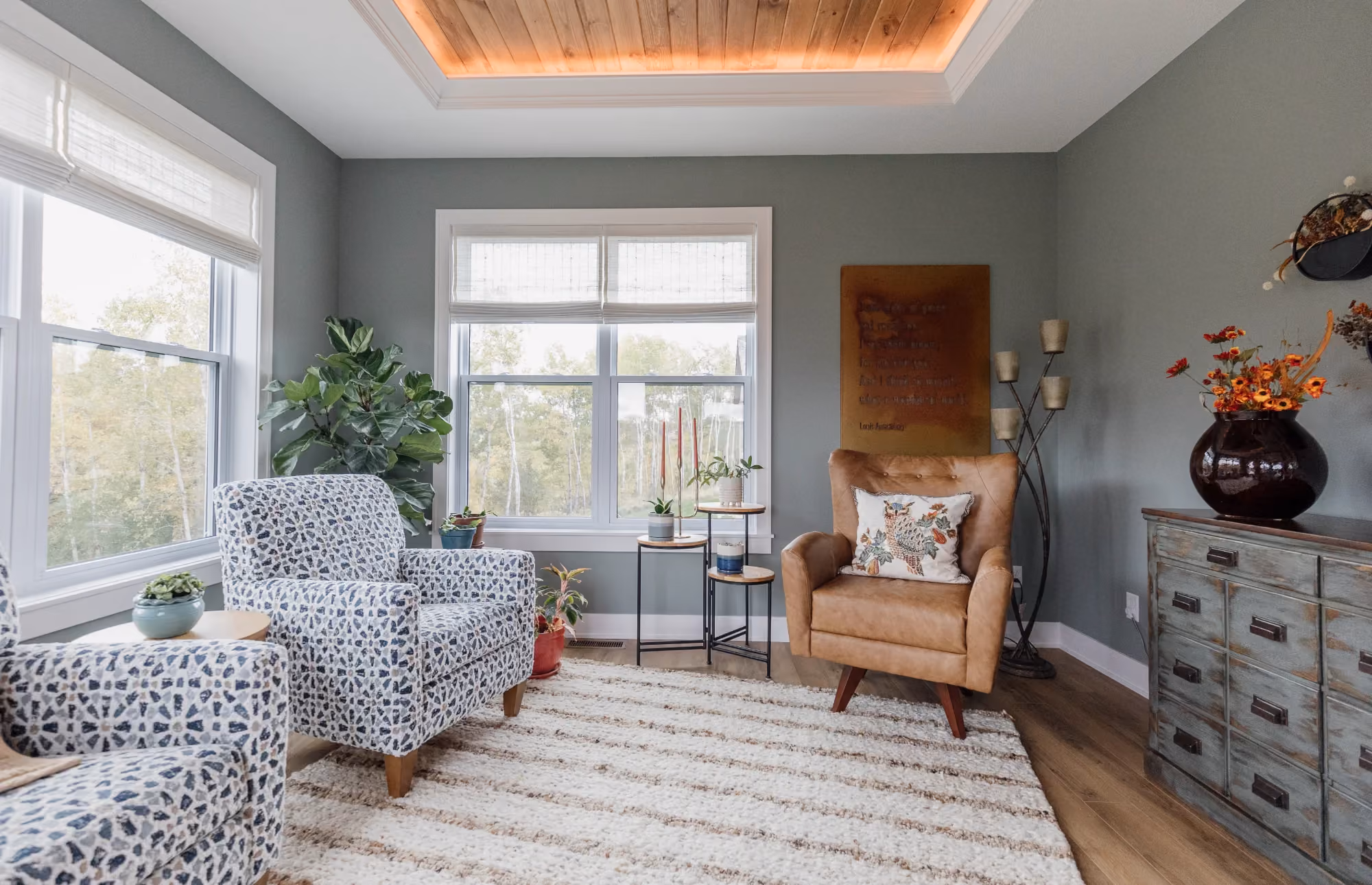 Living room with patterned sofa, armchair, and large windows