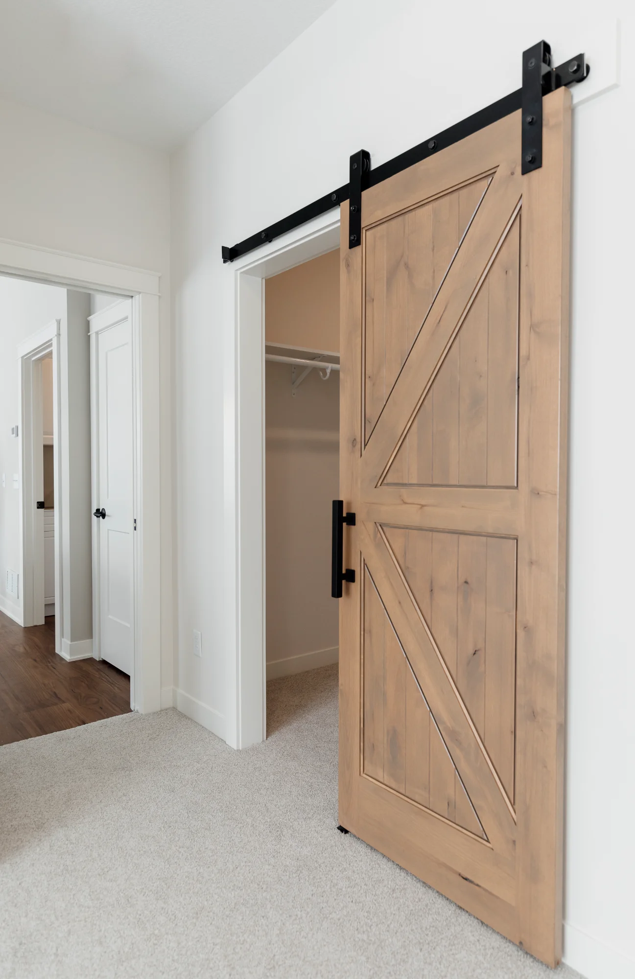 Light wood sliding barn door on wall track