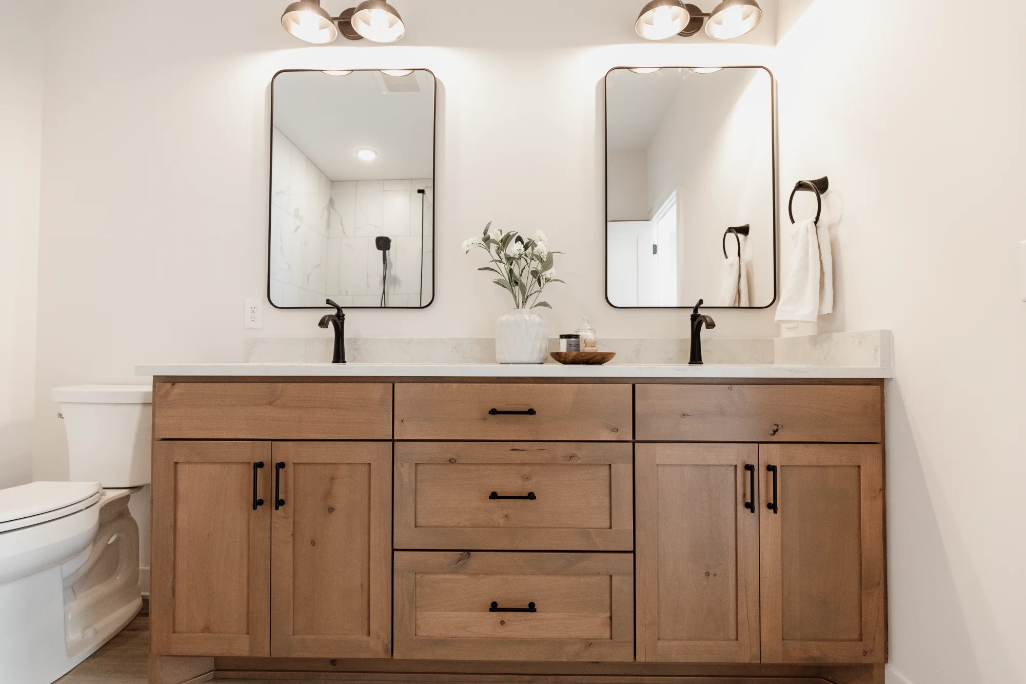 Double-sink bathroom vanity with mirrors and wood cabinets