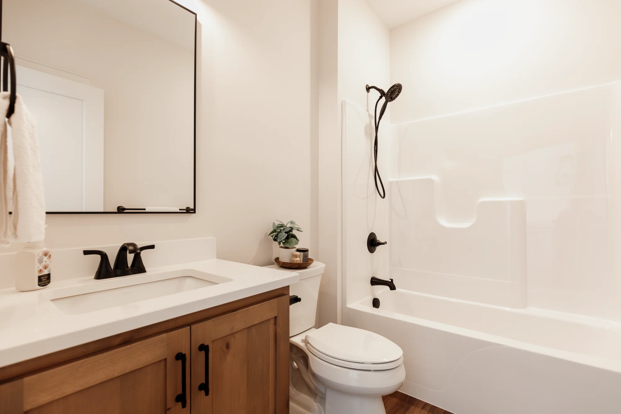 Bathroom with vanity, toilet, and bathtub shower combo