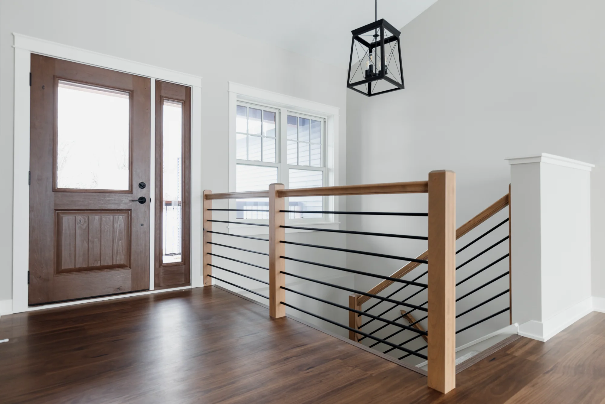 Entryway with wood front door and staircase railing