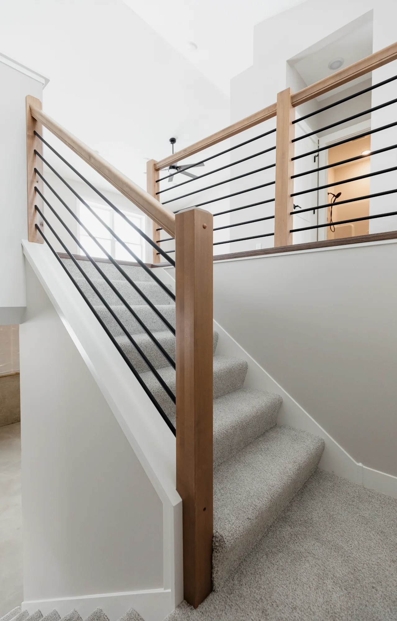 Modern staircase with metal railing and wooden handrail