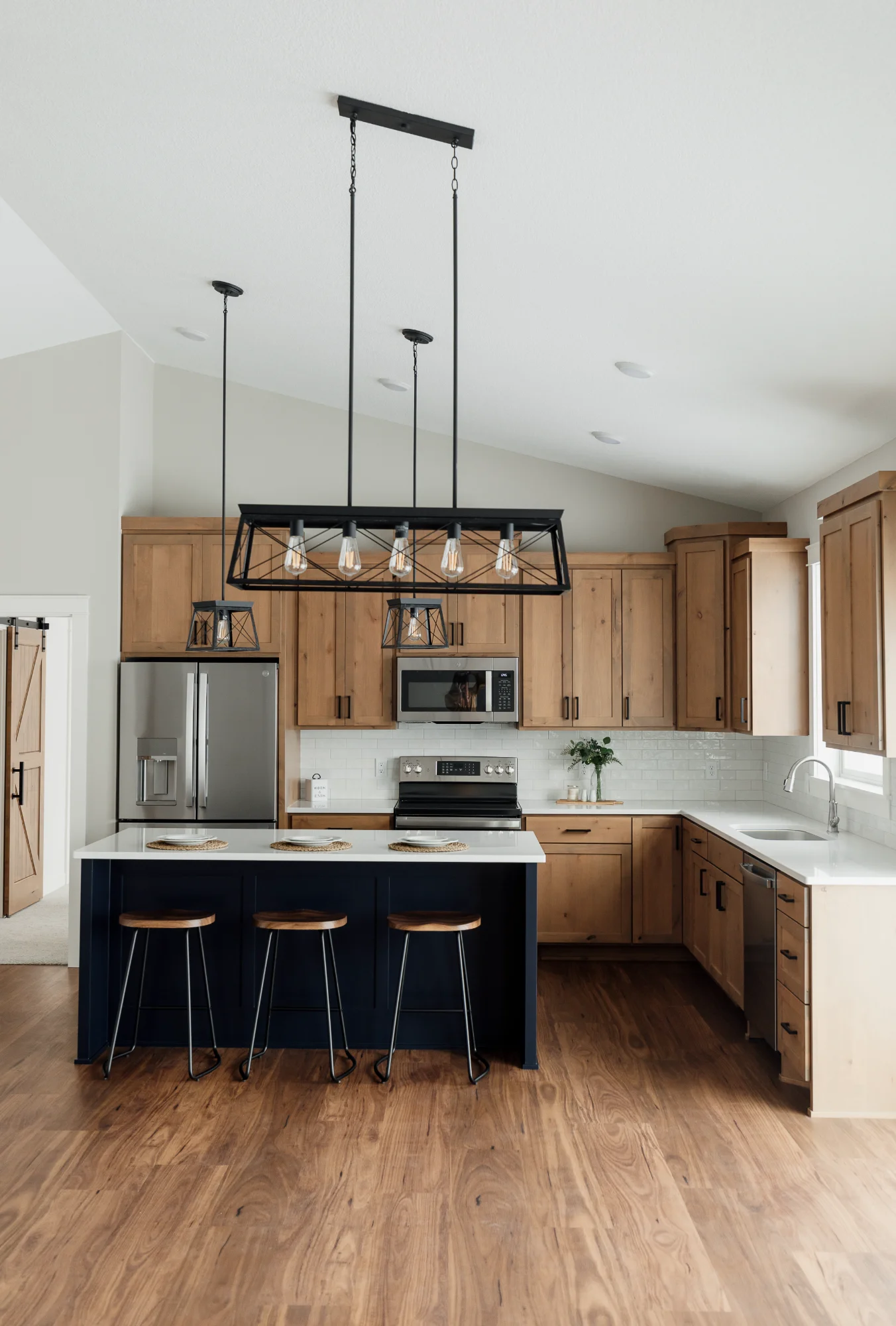 Wide view of kitchen with island and pendant lighting