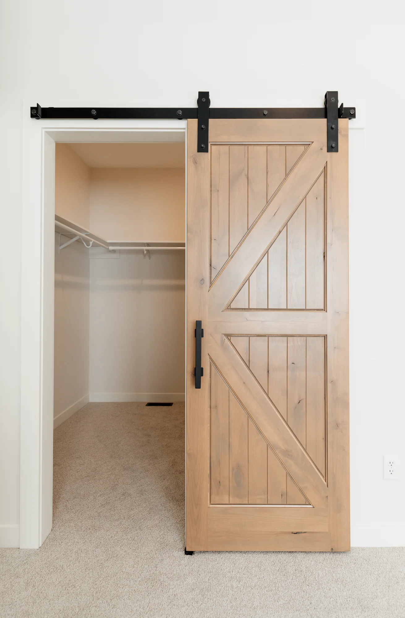 Light wood sliding barn door in hallway