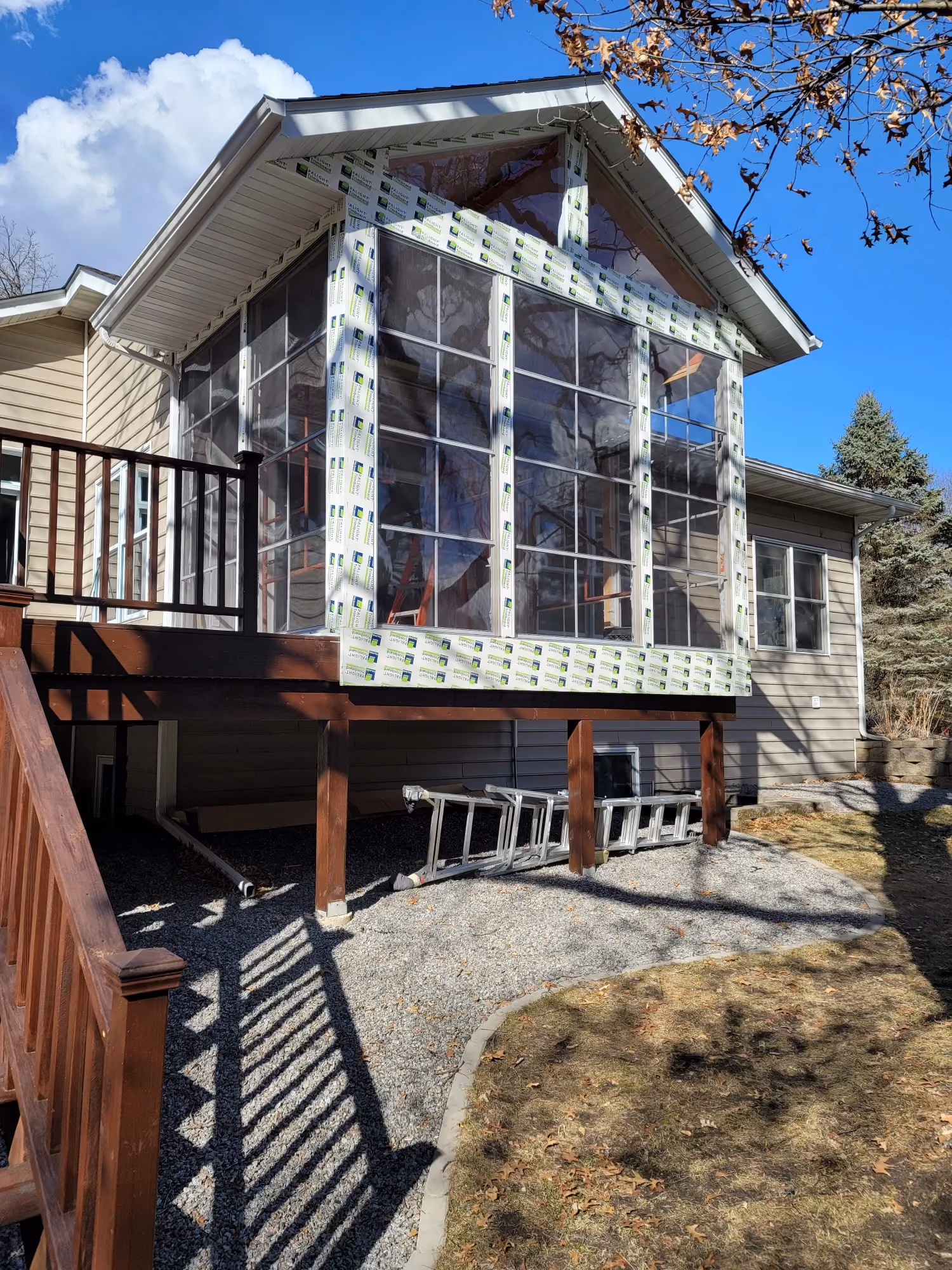 Rear exterior view of house with balcony and deck stairs