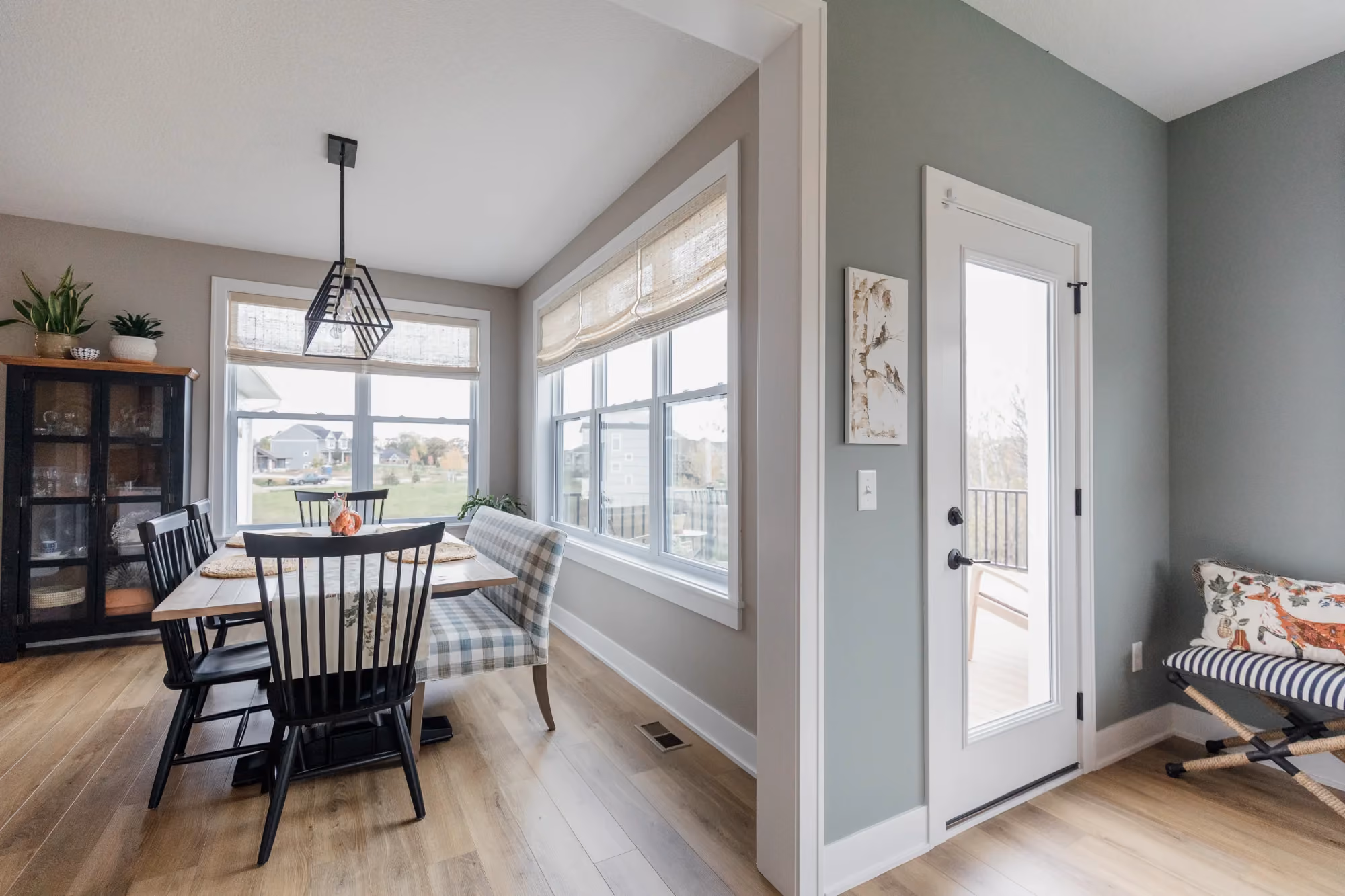 Dining nook with round table by windows and entry door
