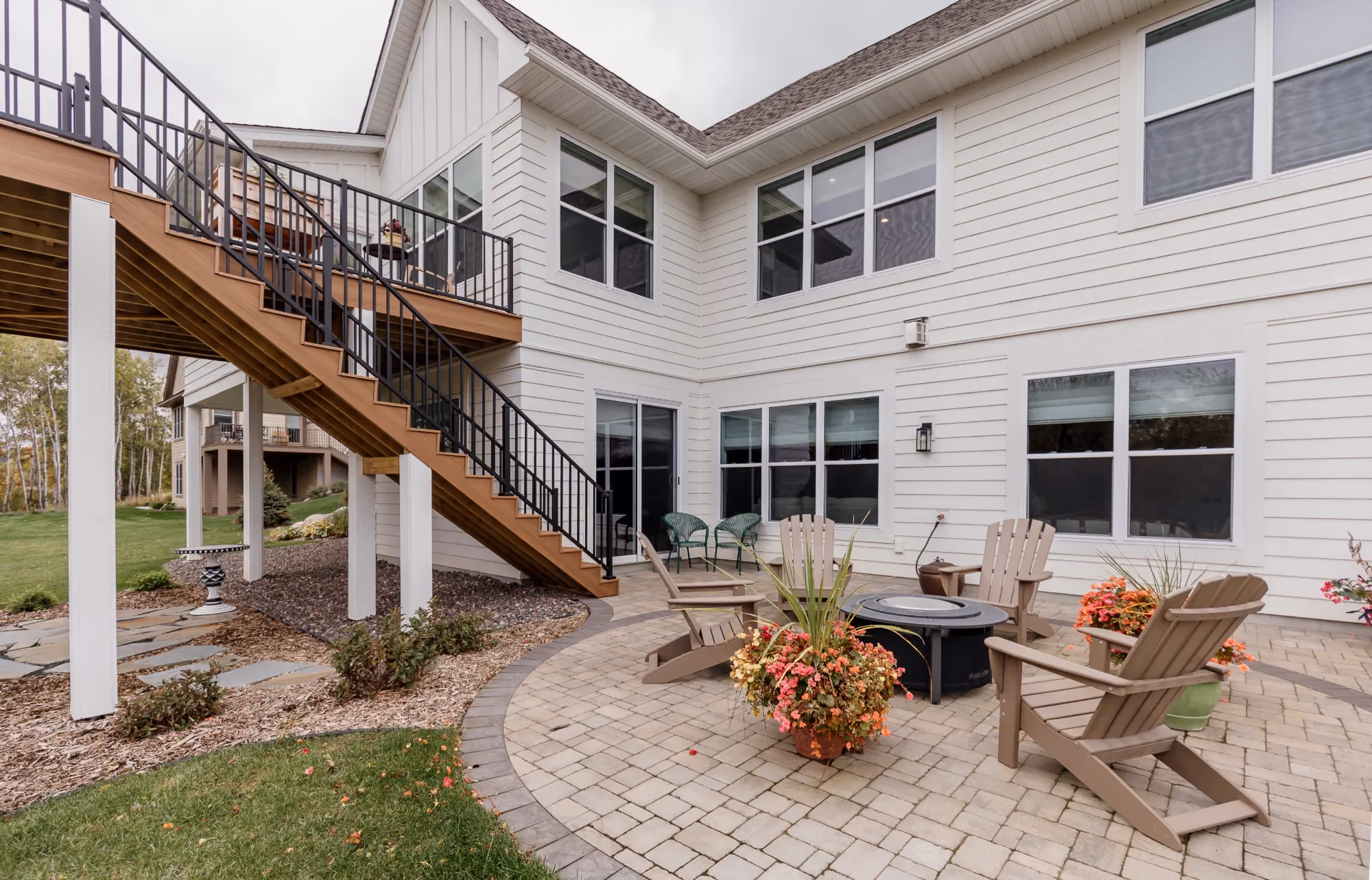 Backyard patio with stairs leading to an upper deck