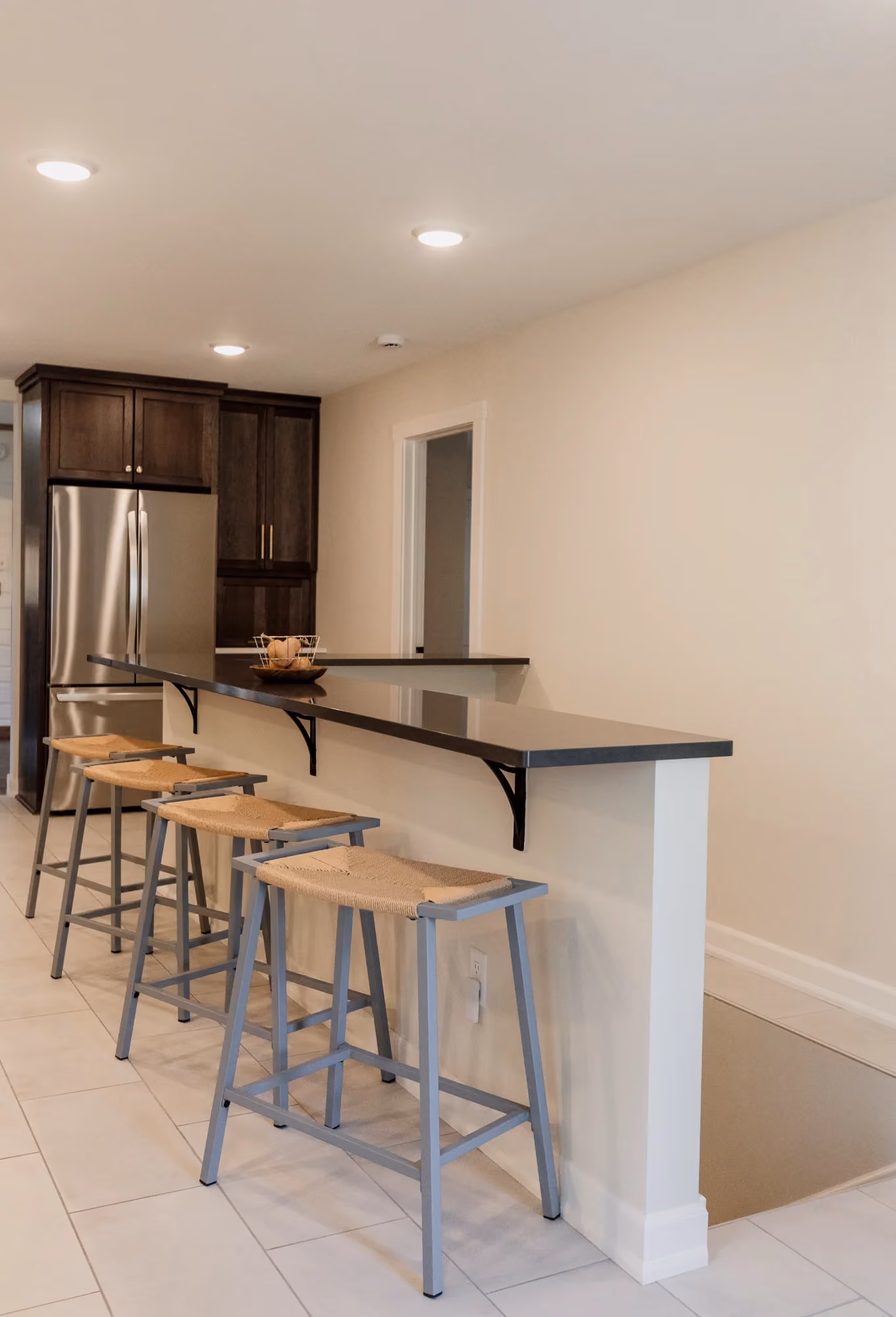 Breakfast bar with stools beside kitchen entry