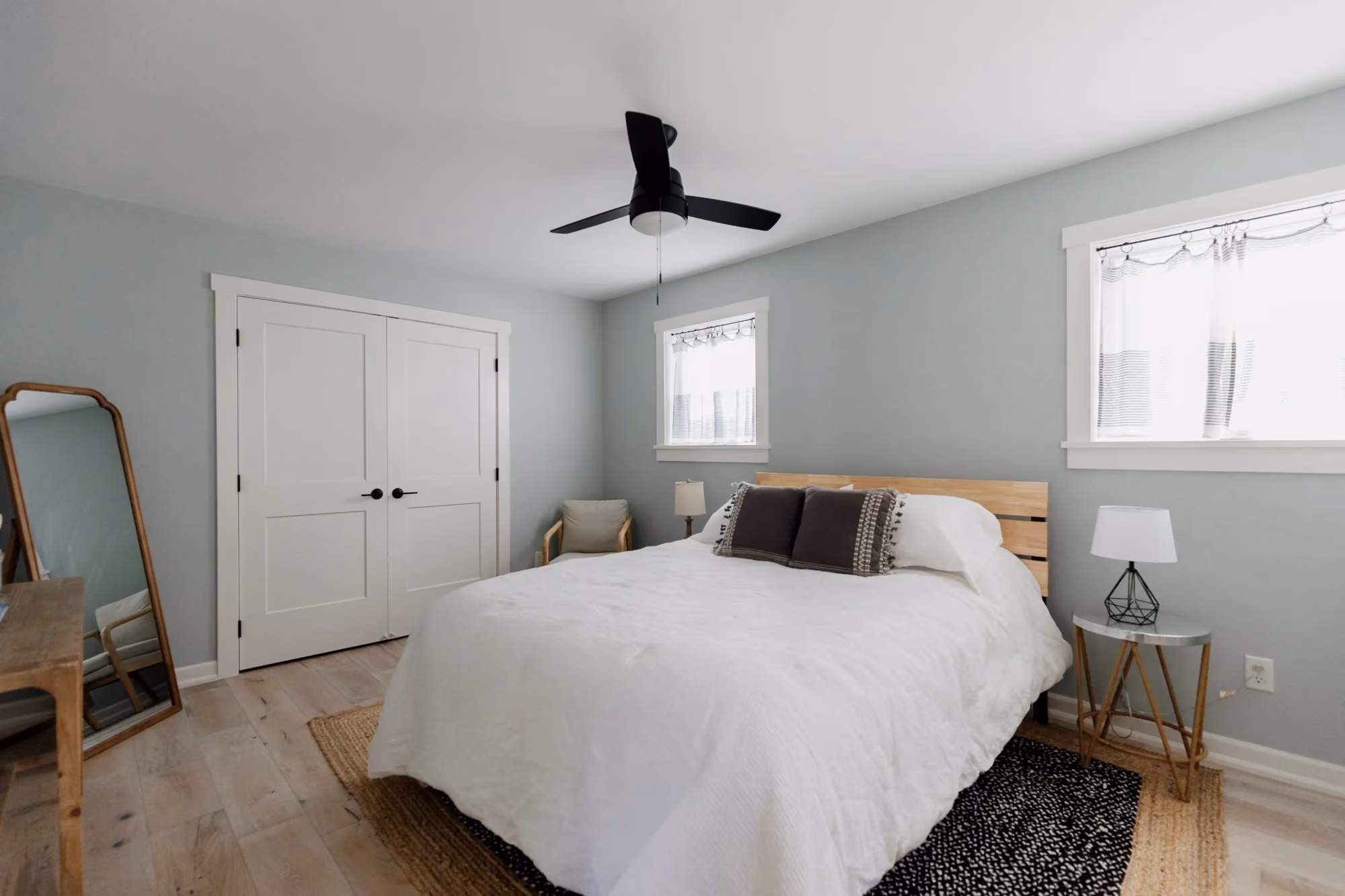 Bright bedroom with white bedding and ceiling fan