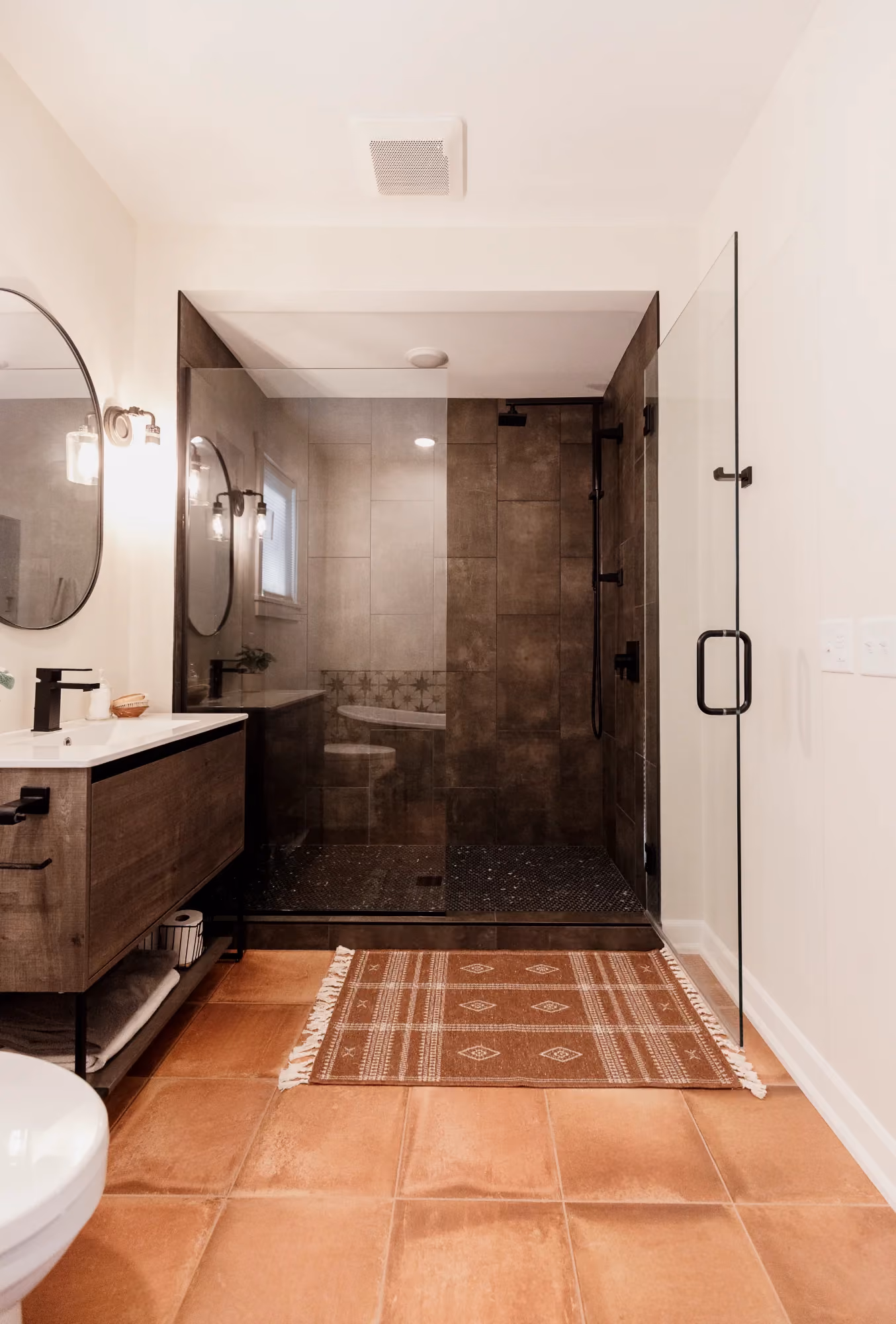 Bathroom vanity with dark shower and tiled floor