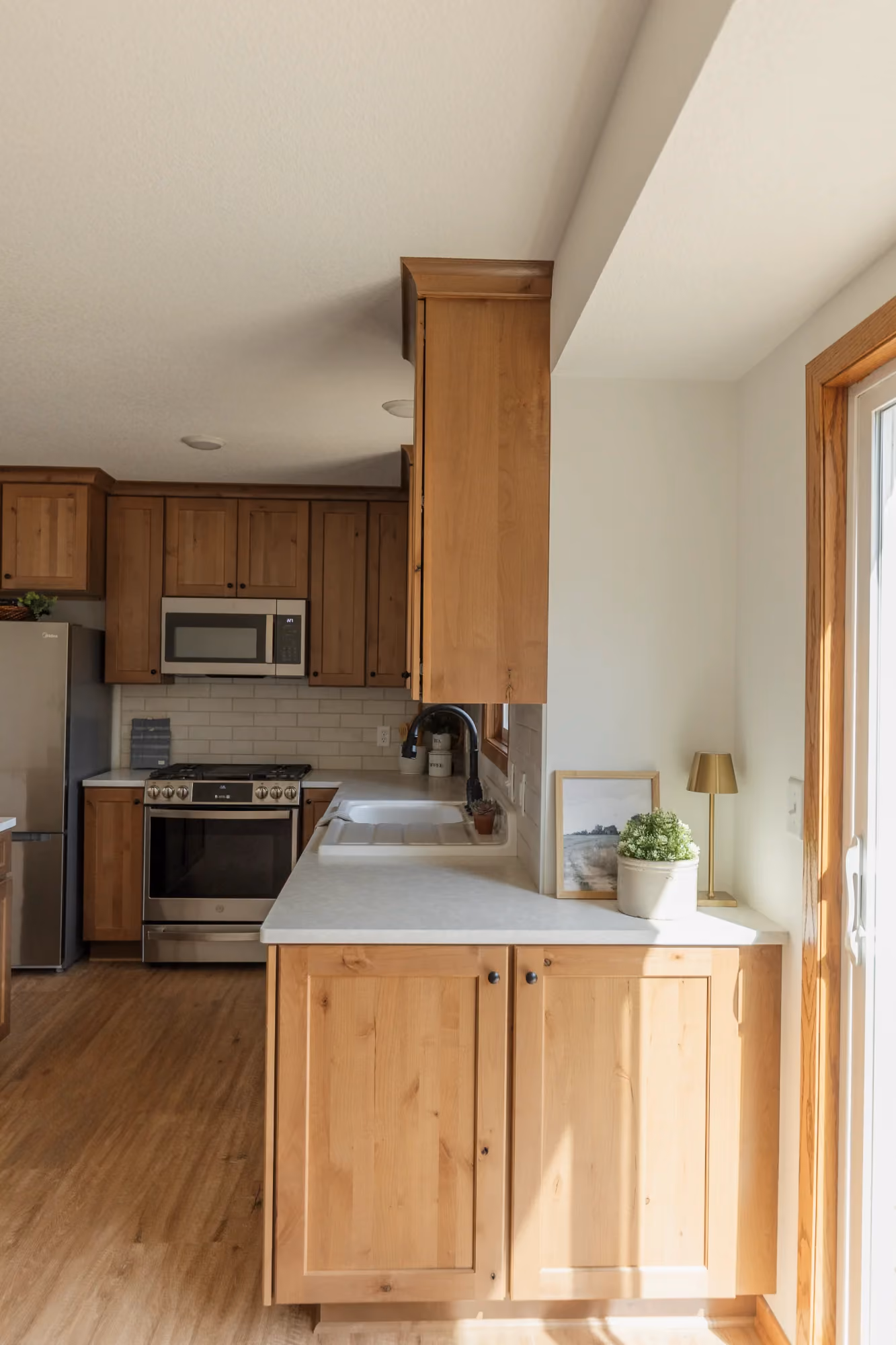 Bright kitchen corner with wood cabinets and stainless appliances