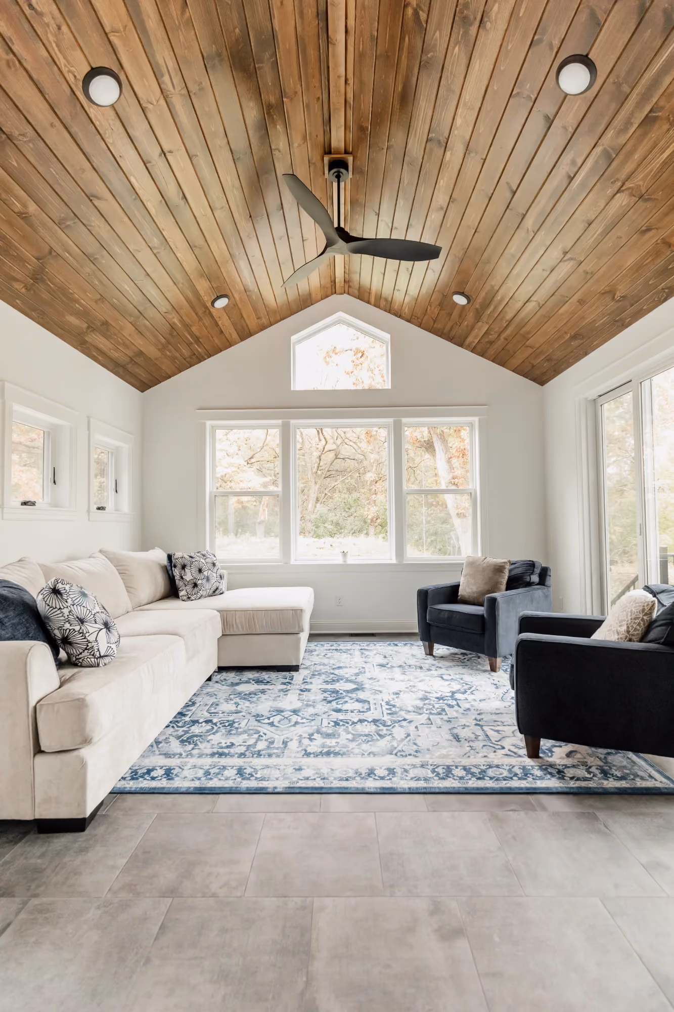 Tall windows in a vaulted living room with wood ceiling