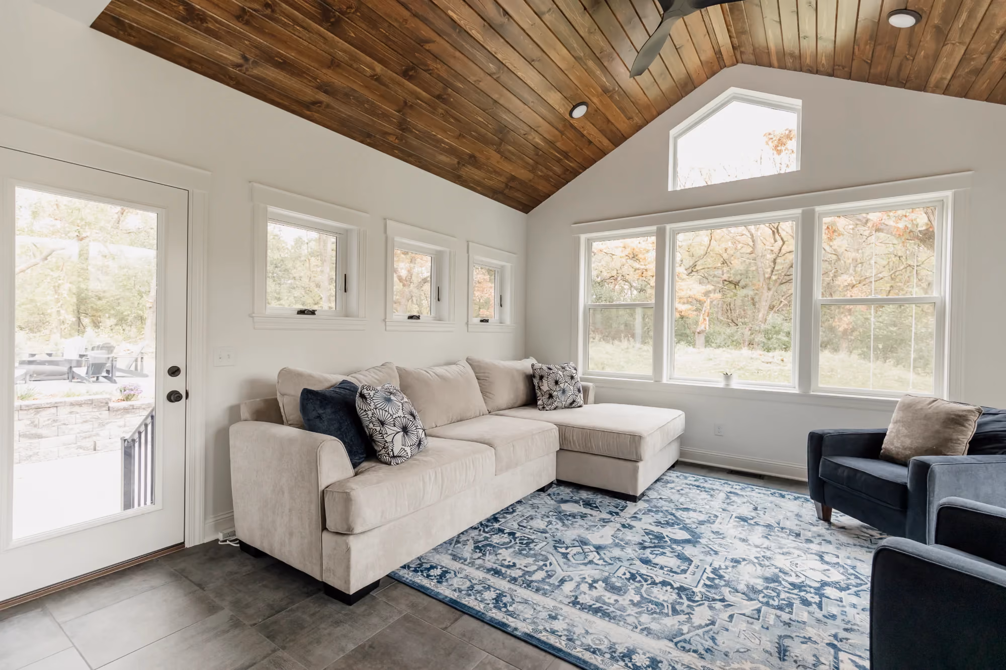 Sunlit living room with sectional sofa and blue rug