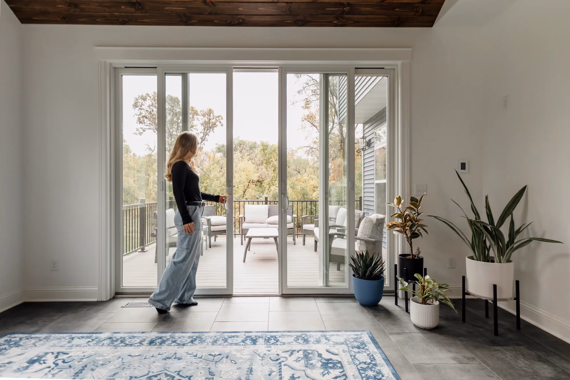 Woman standing in bright entryway with glass doors