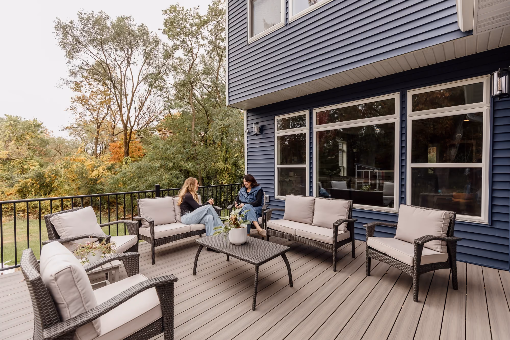 Deck seating area next to blue house exterior