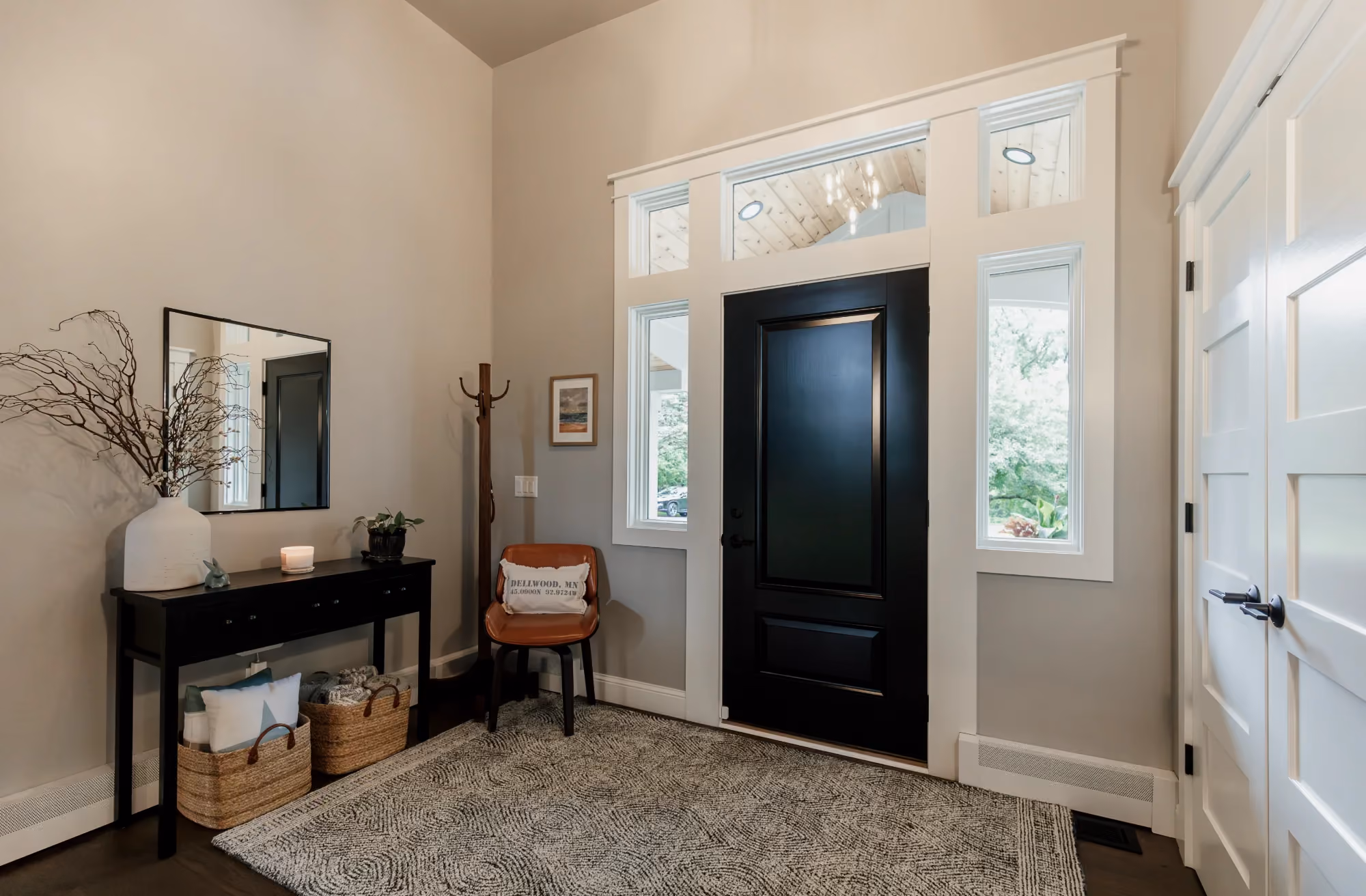 Entryway with black front door and console table