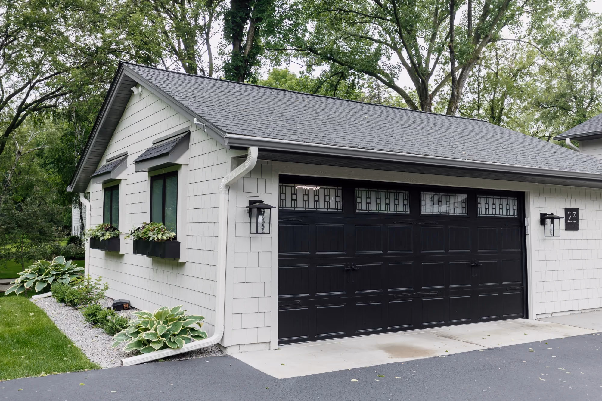 White garage exterior with black door and metal roof