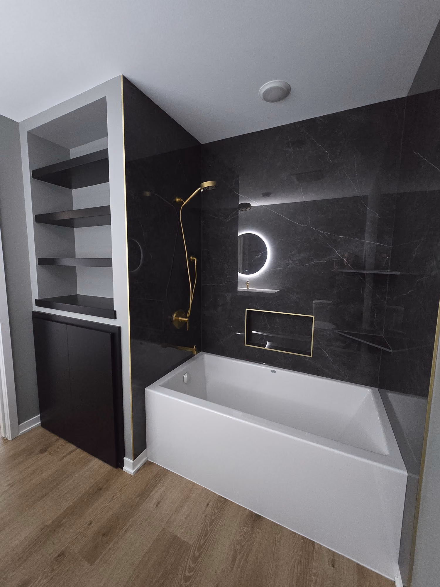 Bathroom with bathtub, dark tile shower, and shelving