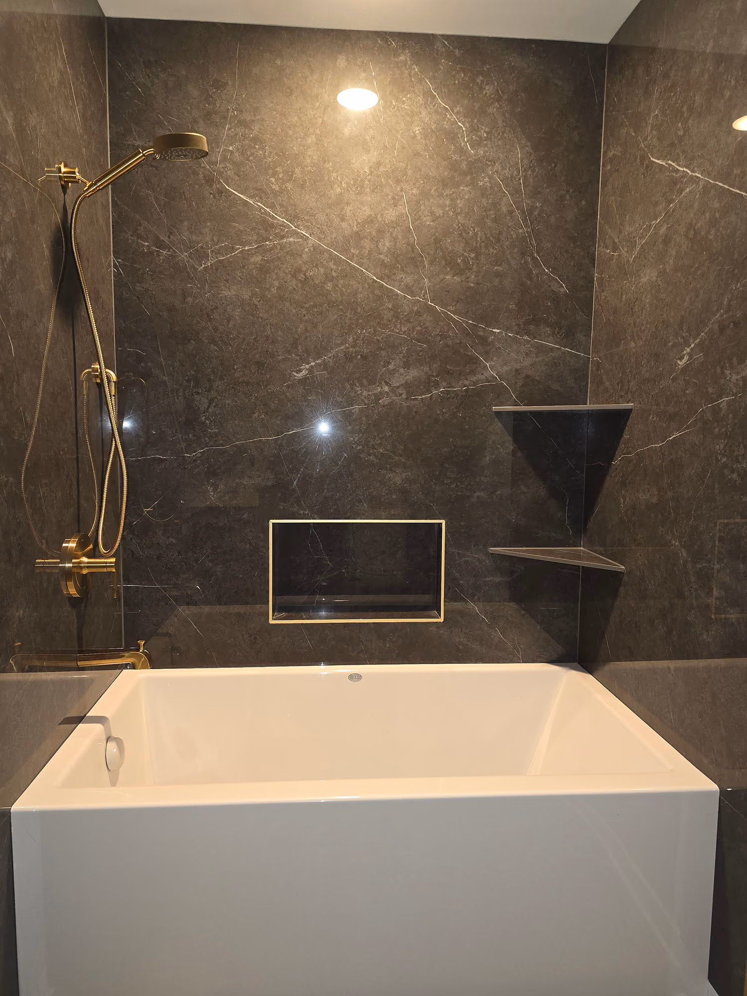 Bathroom sink with dark stone shower wall
