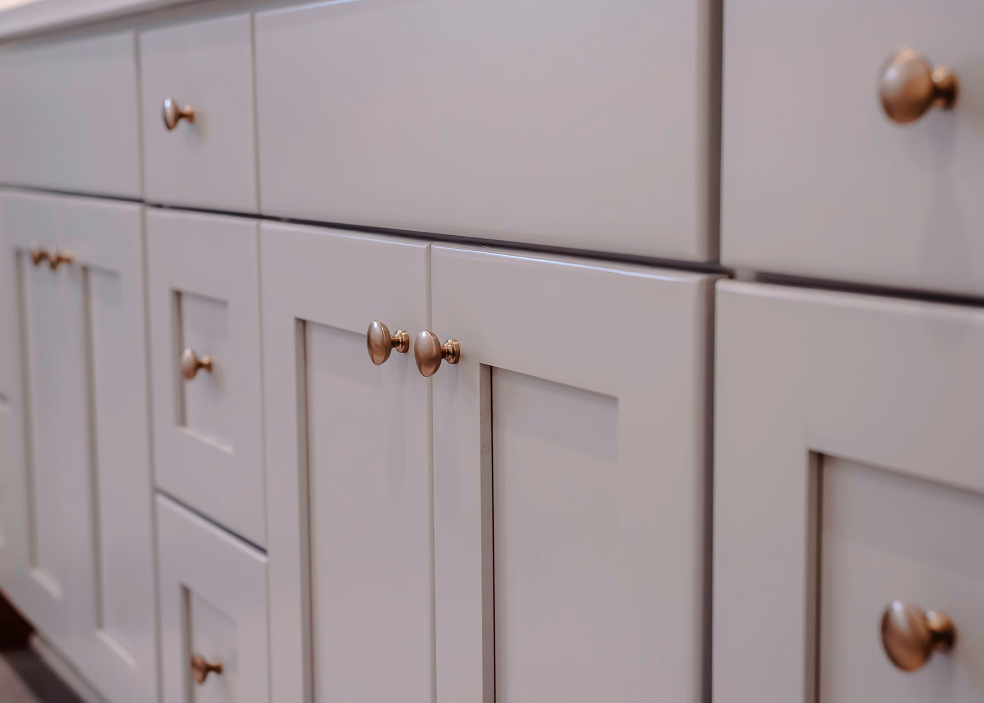 White kitchen cabinets with brass knobs close-up