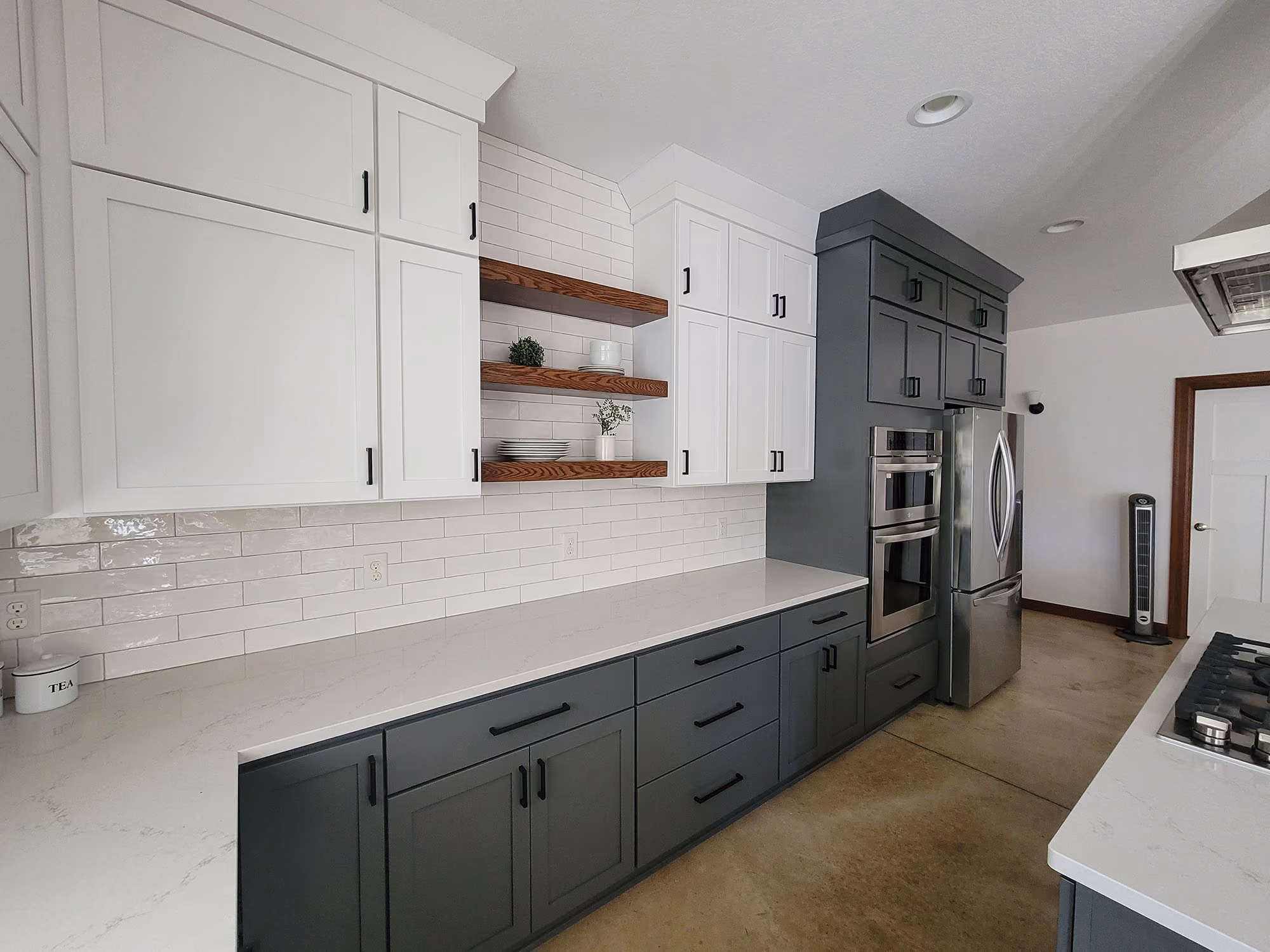 Galley kitchen with gray lower cabinets and pantry hallway