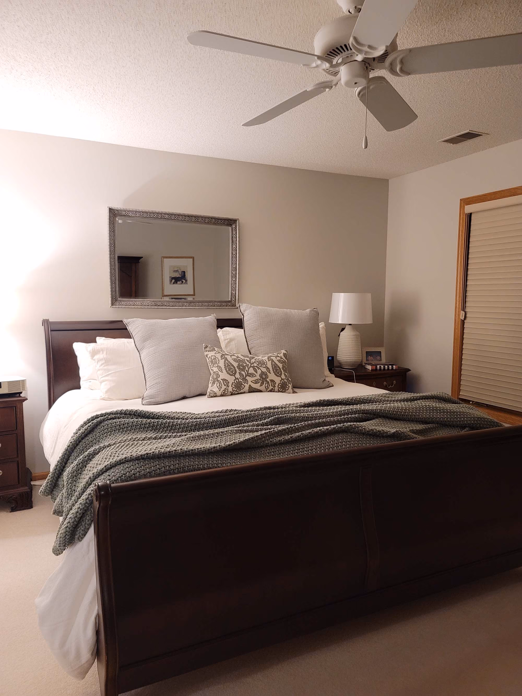 Bedroom with ceiling fan and dark comforter