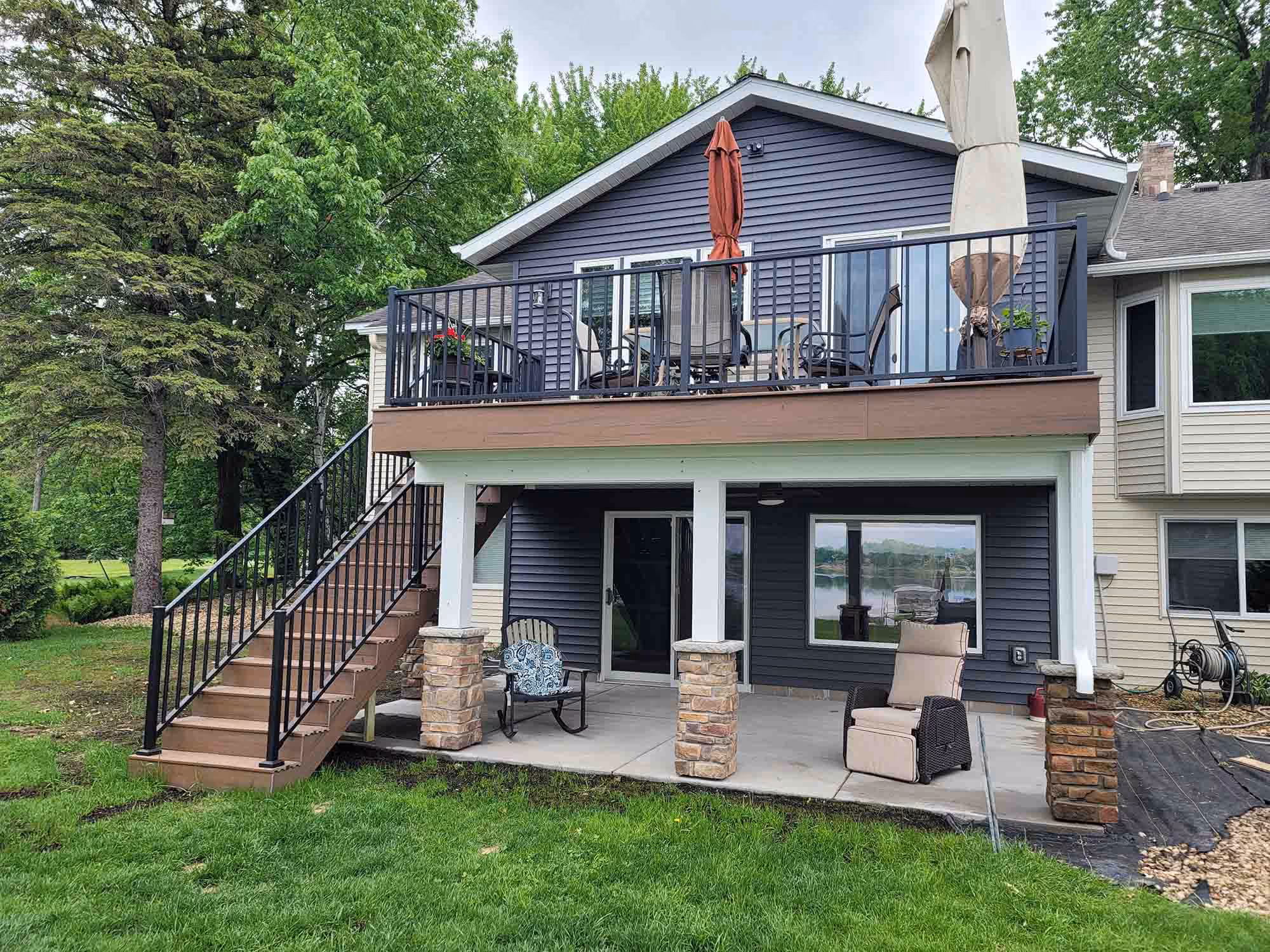 Backyard view of deck, patio, and stairs