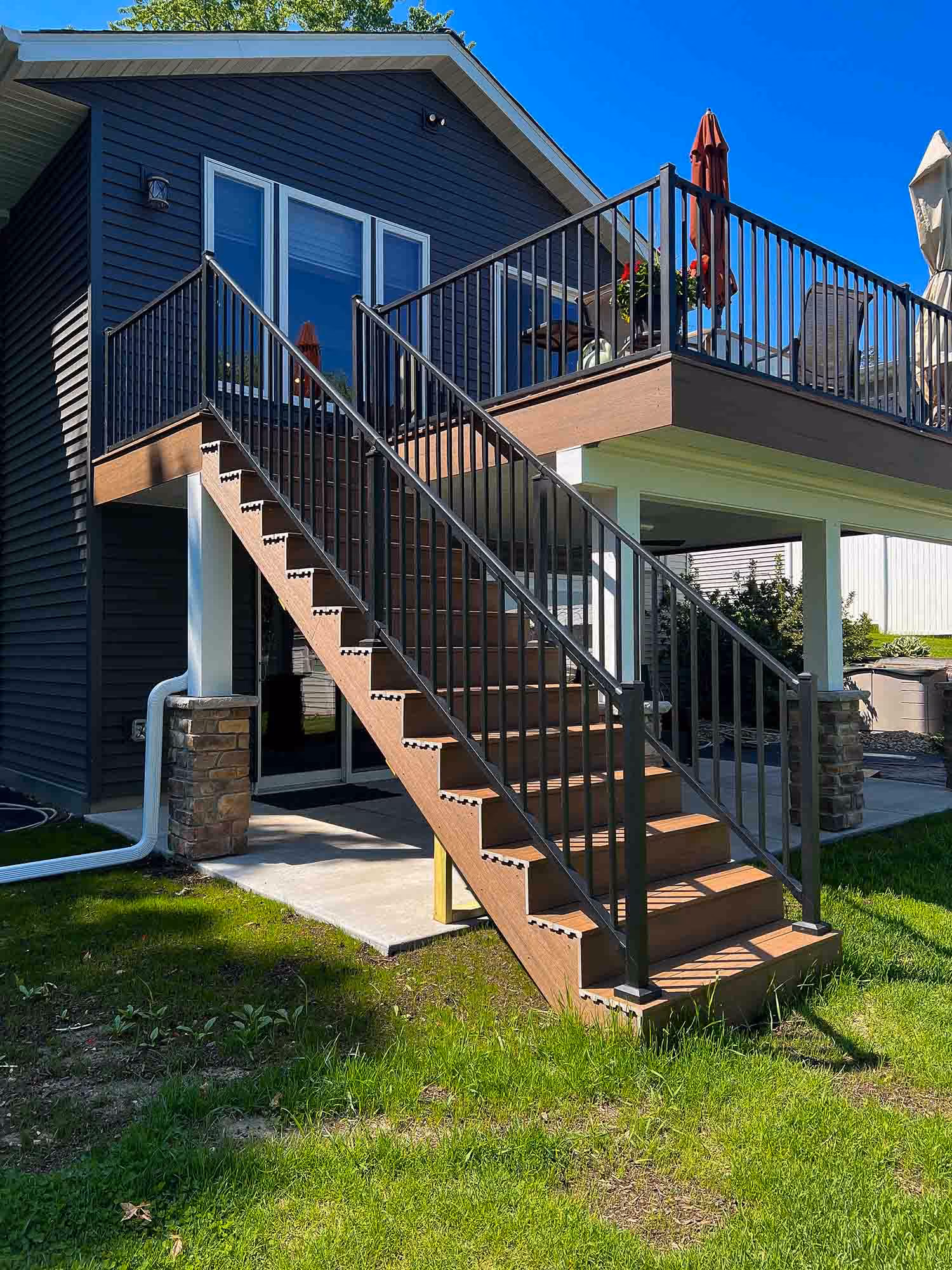 Backyard view of elevated deck with stairs