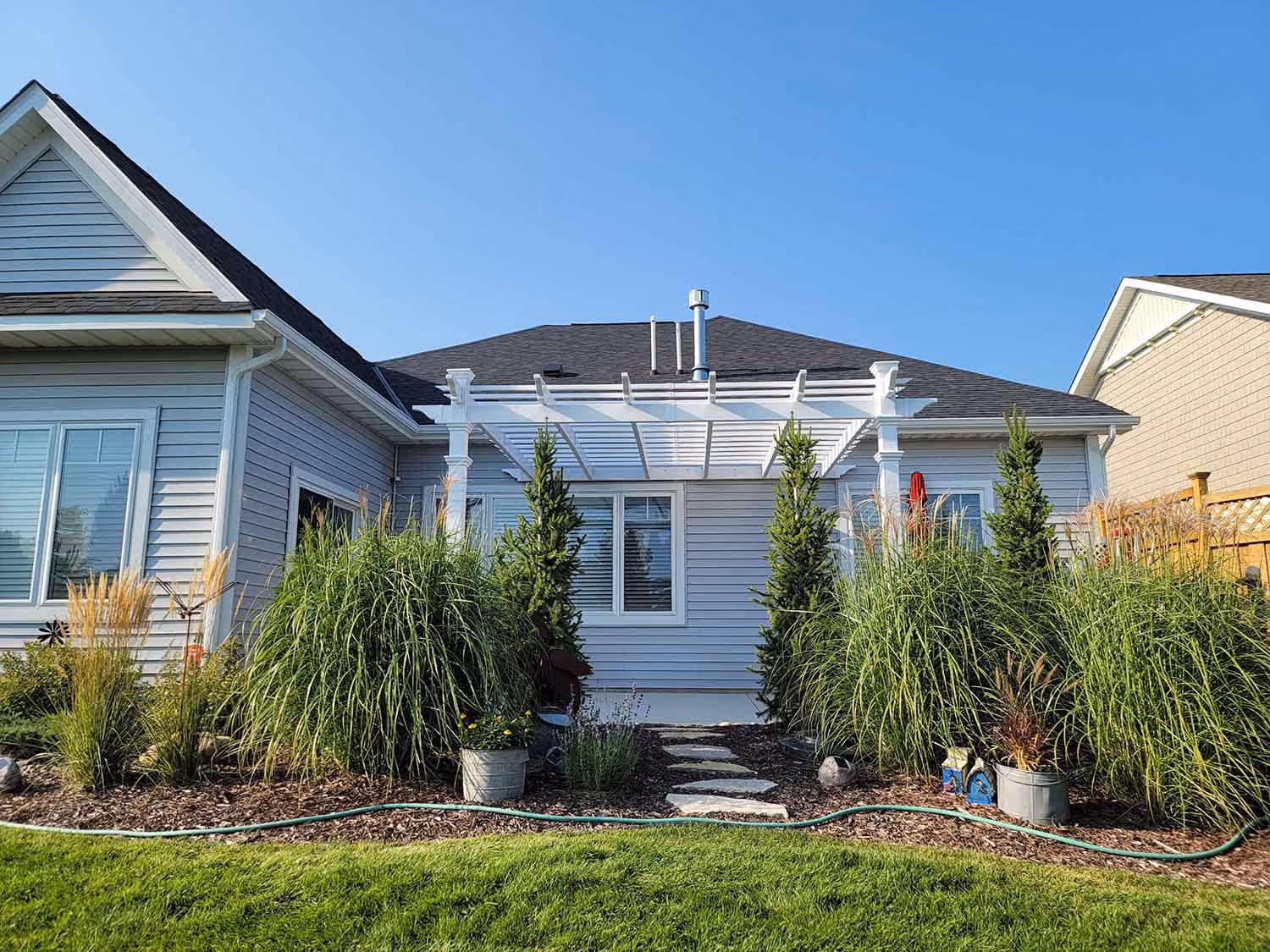 Single-story house exterior with landscaped shrubs
