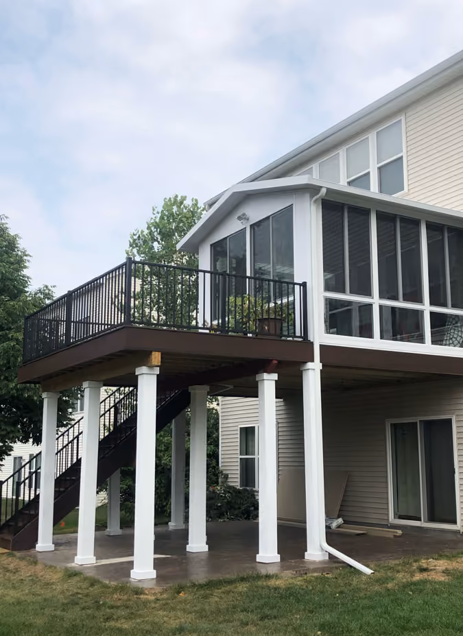 Elevated screened porch with white supports beneath house