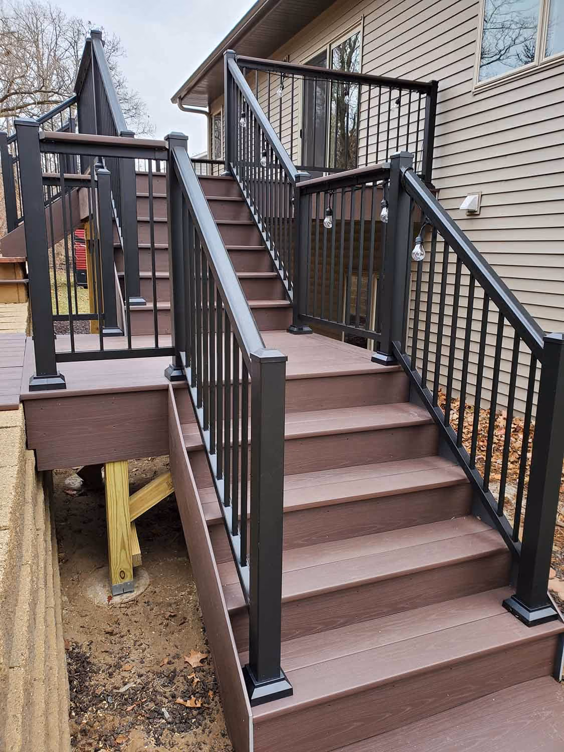 Close-up of deck stairs with black railing